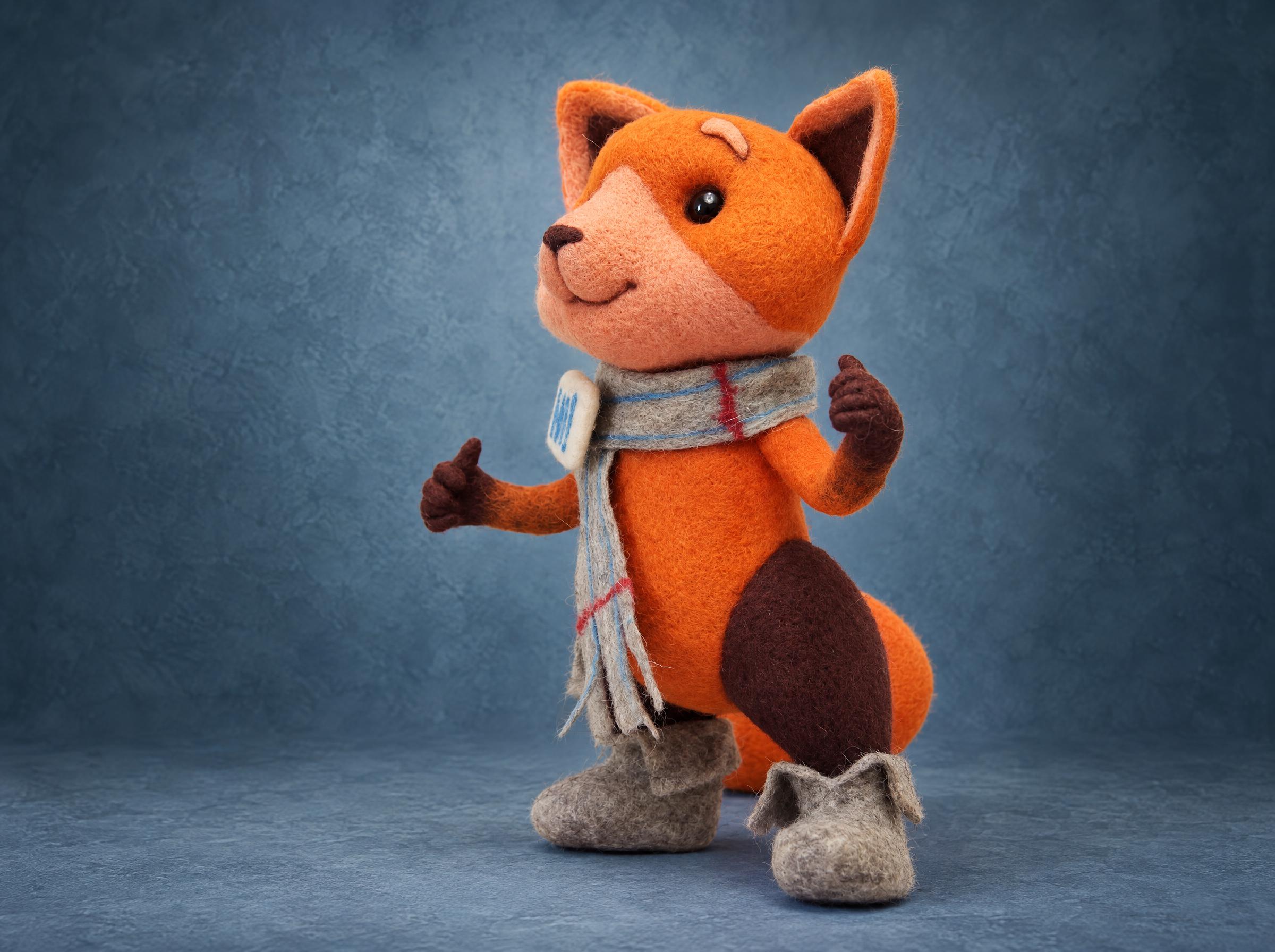 Felted Viber fox toy in scarf and felt boots Felted Viber fox toy from the side, orange wool, grey scarf and felt boots, a custom sticker plush made to order