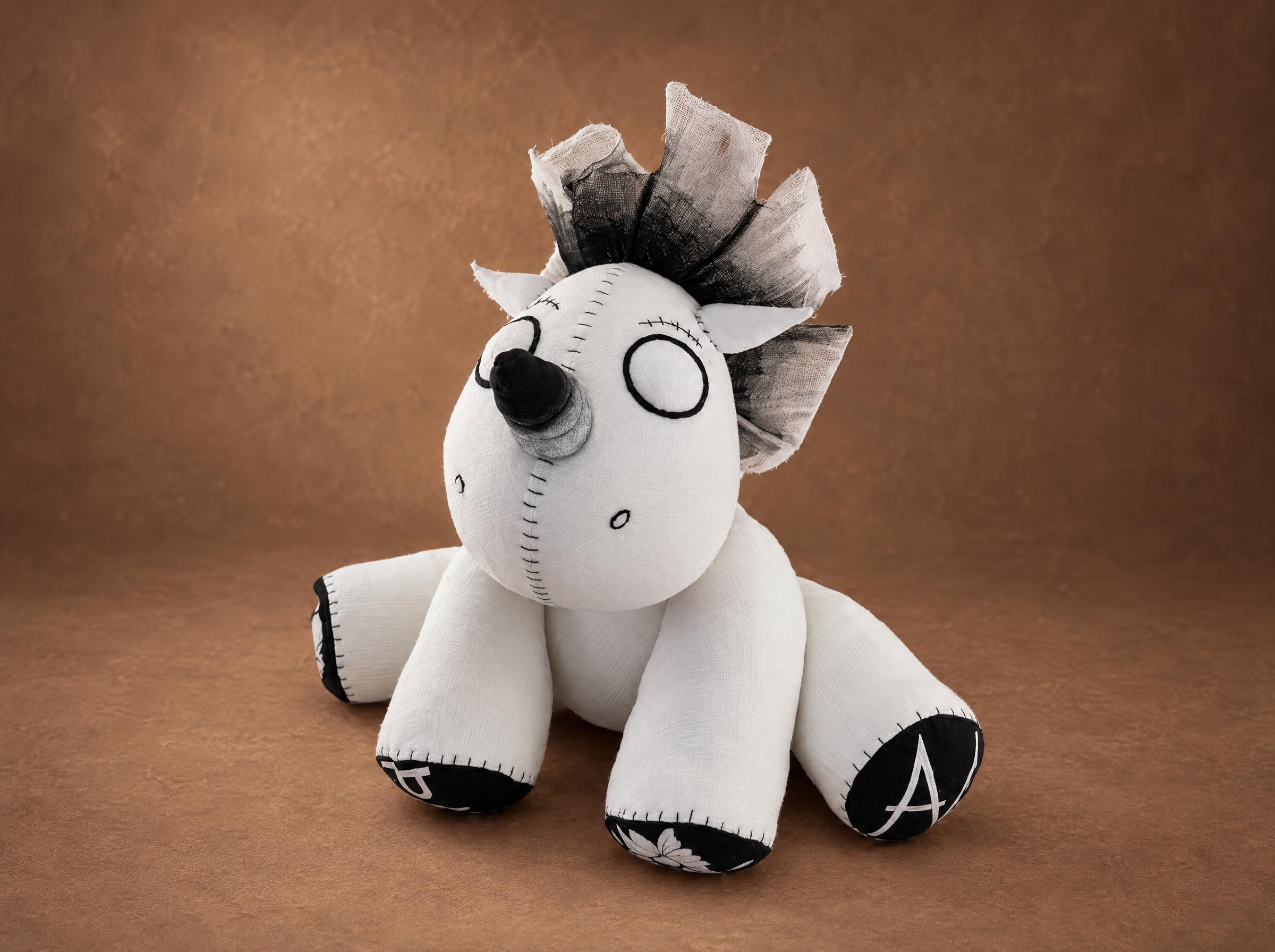 Voodoo unicorn plush sewn from an illustration: white body, stitched X eyes, black gauze mane, made to order