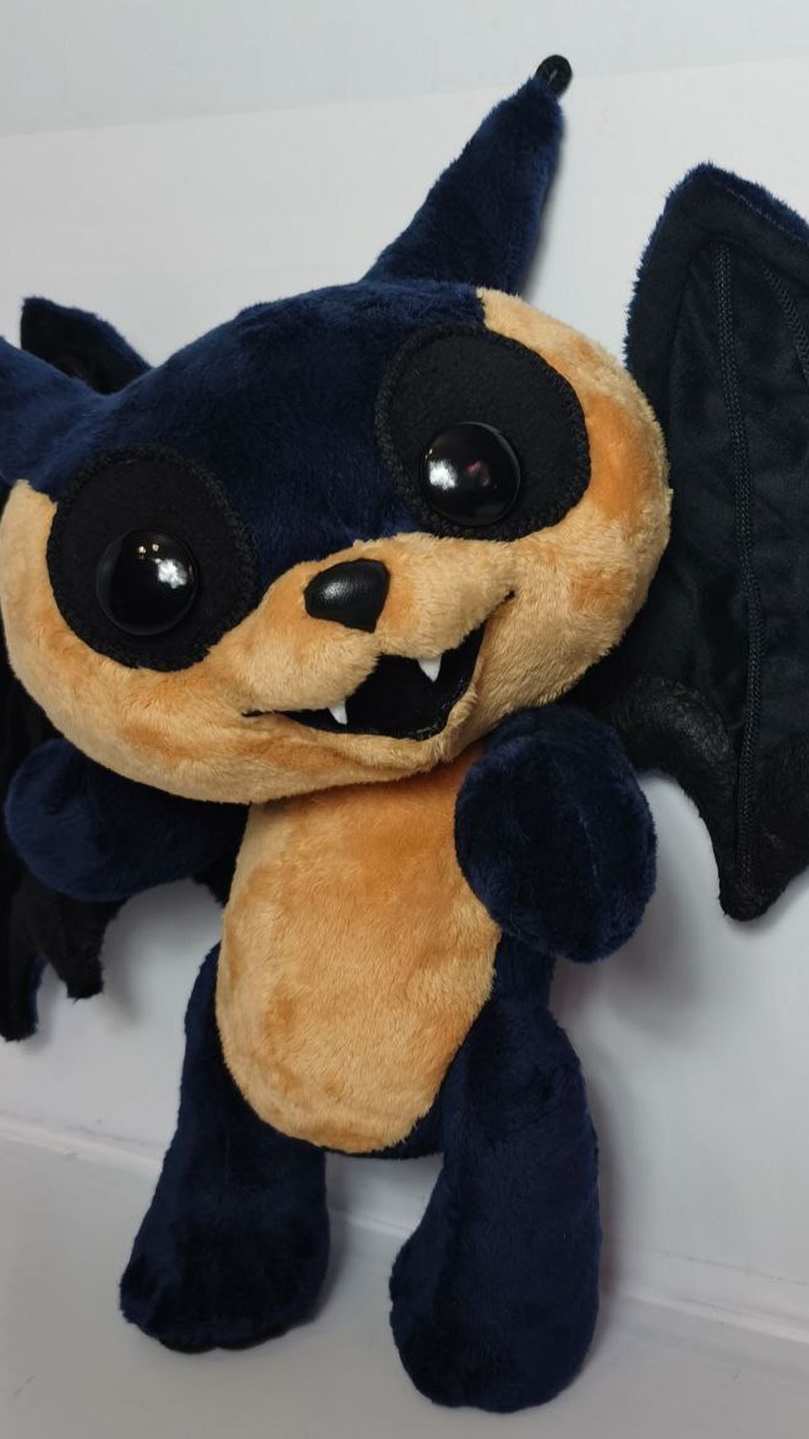 AI-generated bat plush, sewn by hand to order: navy faux fur, glossy eyes on black felt, fangs, velvet wings
