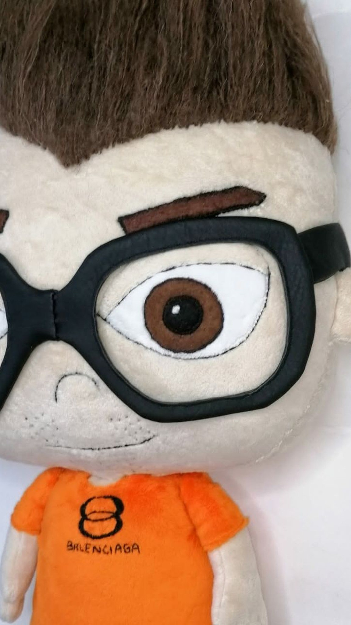 Anime doll of a friend with a half smile, felt brows and an orange logo T-shirt, handmade to order