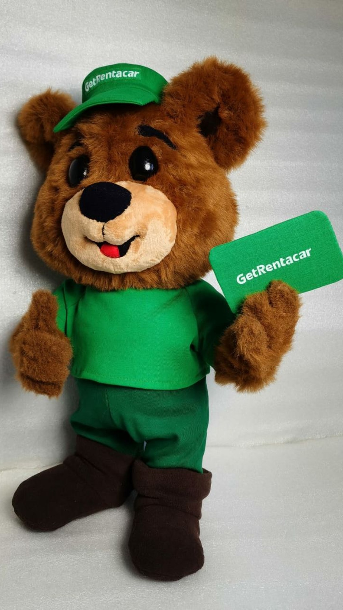 Corporate bear mascot plush facing forward: thumbs-up paw, green cap, branded green card, custom made to order