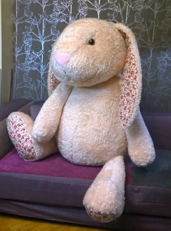 Big bunny plush with floral feet Big bunny plush made to order, 1.2 m: floral-print foot soles, long arms, peach faux fur, sitting on a sofa