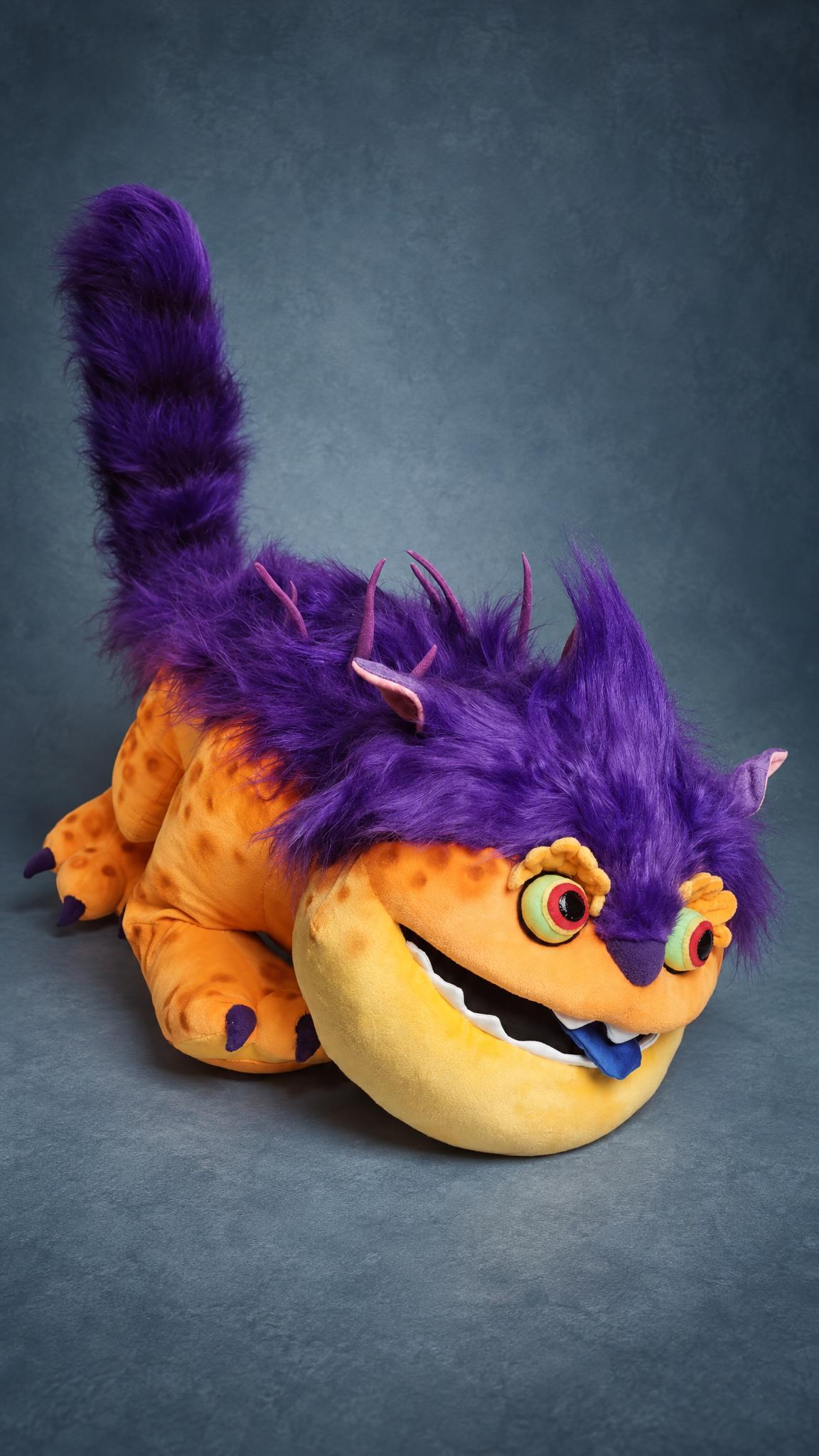 Orange monster plush lying on its belly, purple fur mane and tail up, Big Orange from Bernard sewn to order