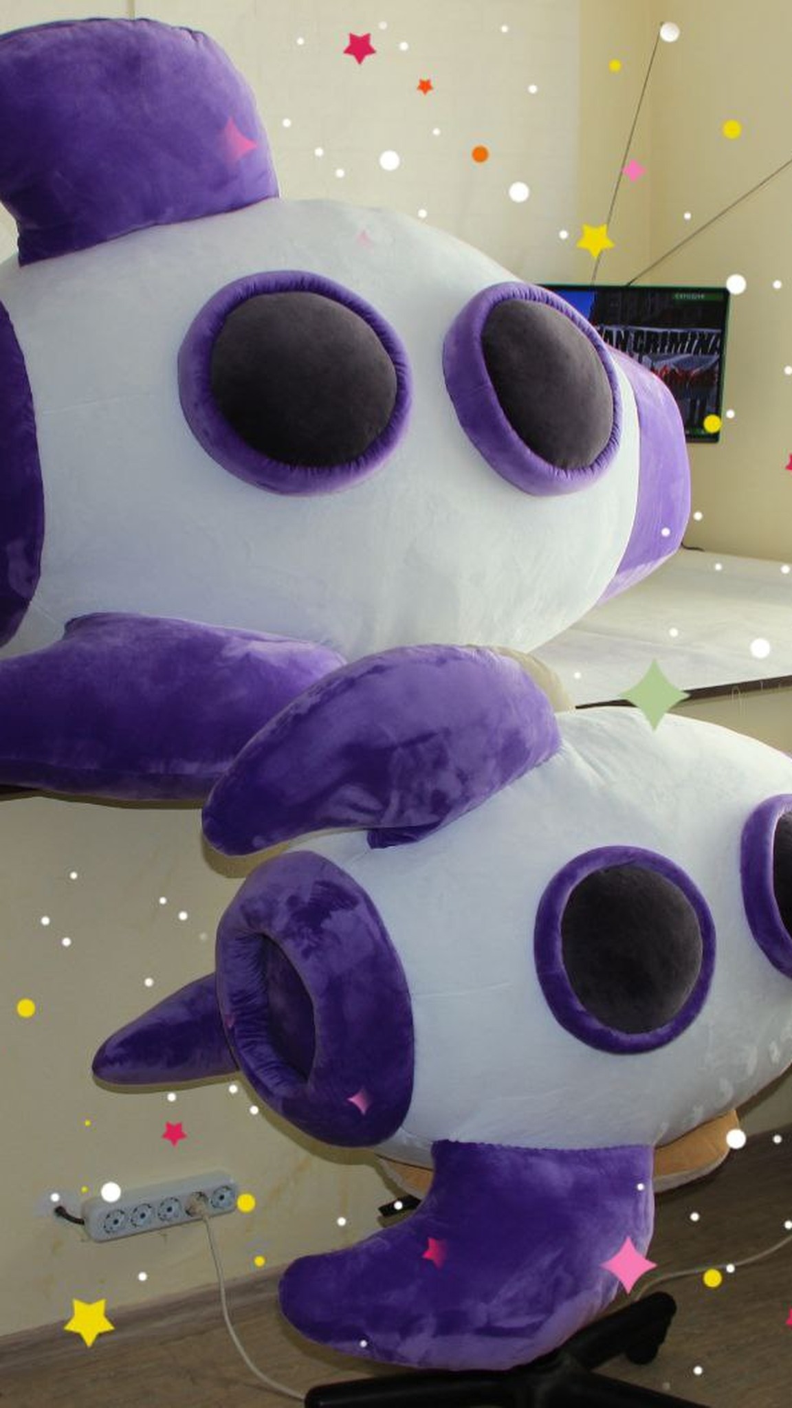 Rocket plush mascots with violet piping around charcoal portholes and curved fins, sewn to order
