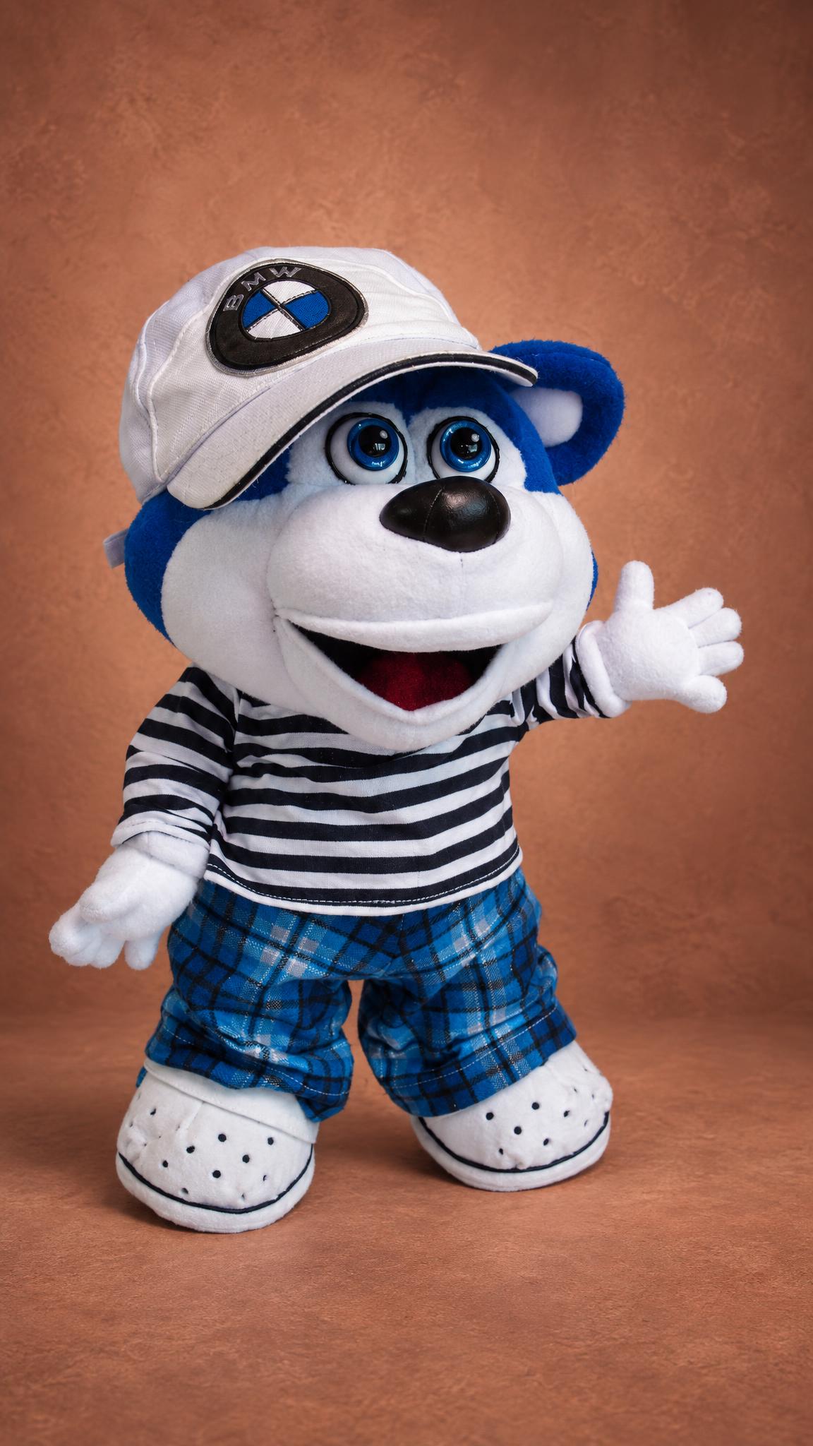 Custom blue bear plush in a white cap and striped top, waving hello, sewn by hand from a drawing
