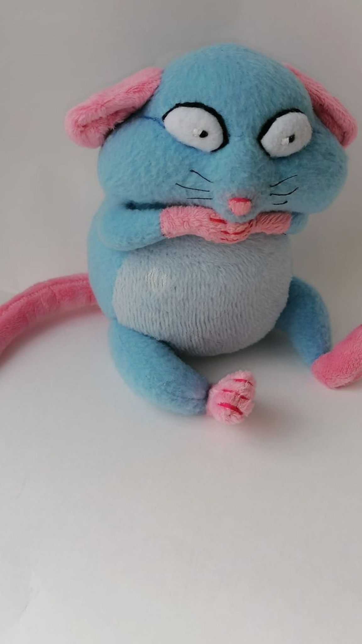 Blue rat plush with big worried eyes and pink paws pressed to its mouth, sewn to order from a sticker