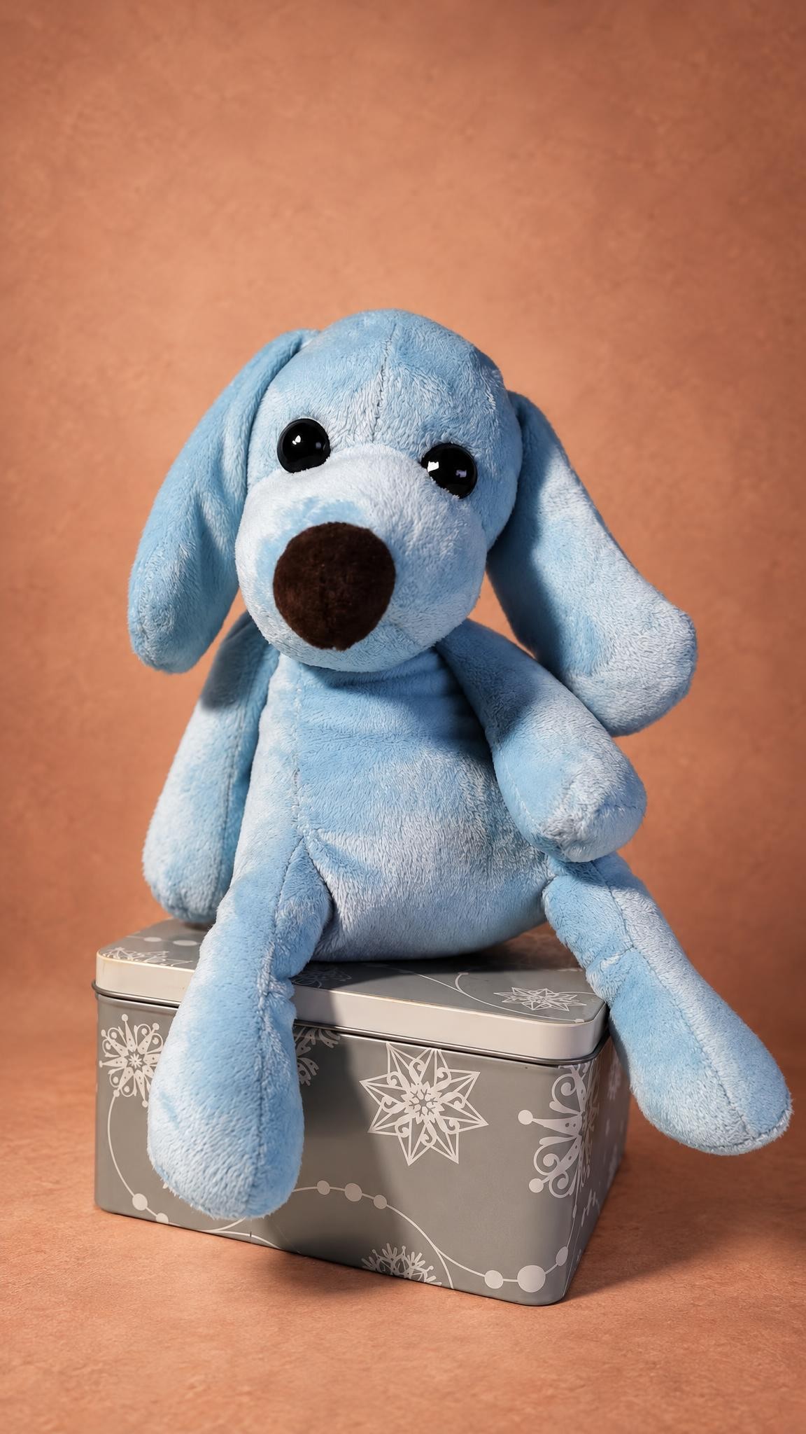 Pale blue stuffed dog sitting on a tin box, long floppy ears, handmade to order from a photo