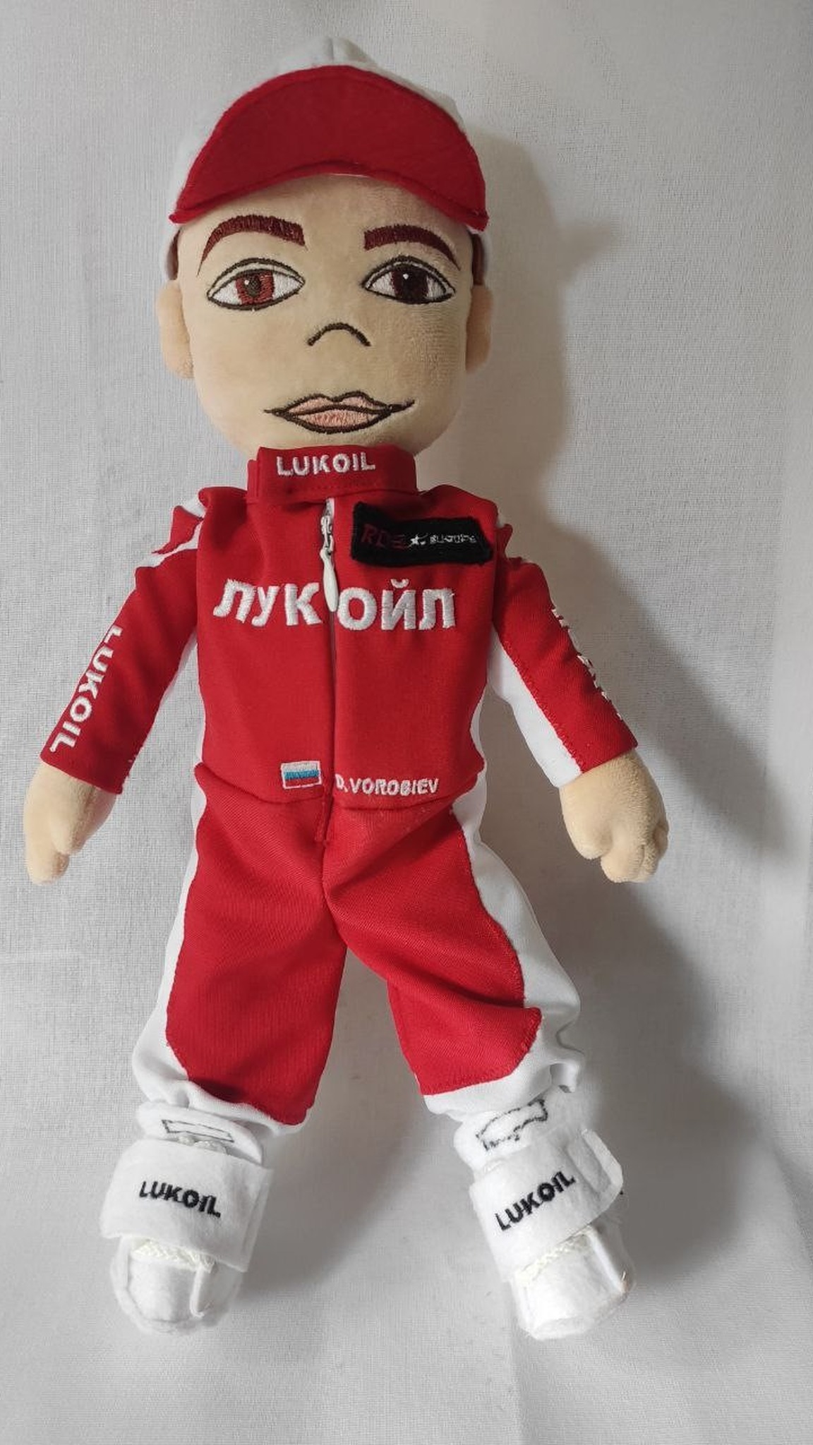 Branded plush doll in a team racing suit, logo and the recipient's name embroidered, custom made to order