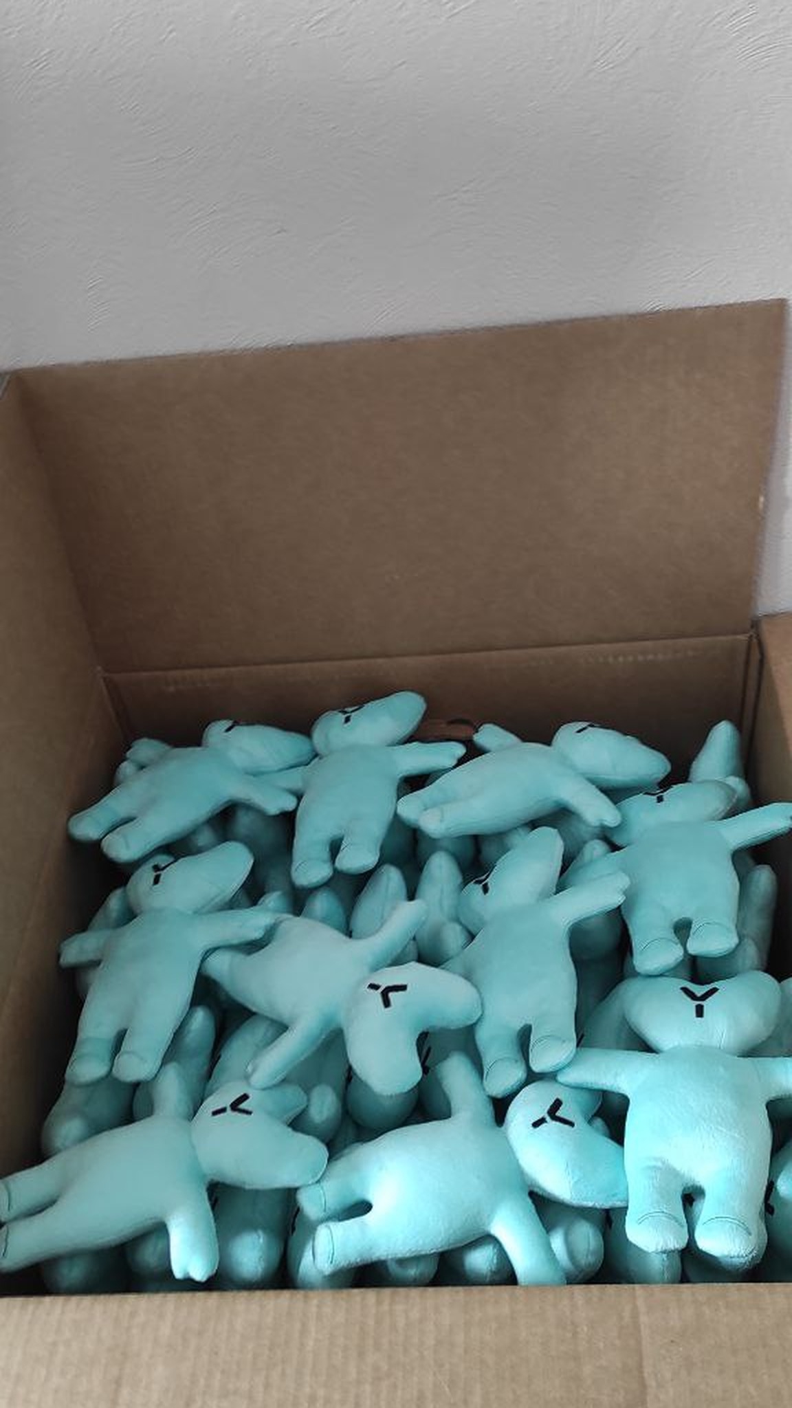 Open box of branded teddy bears with logo faces, mint corporate gifts handmade to order