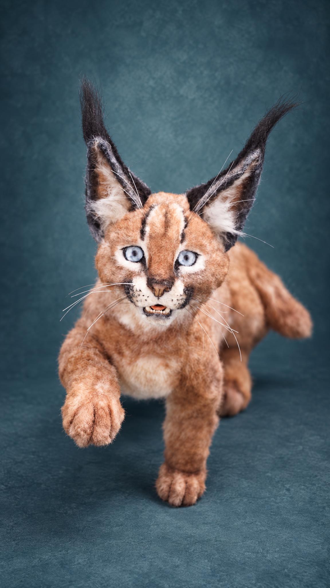 Handmade caracal plush stepping forward with one paw raised, tawny coat and black ear tufts, made to order