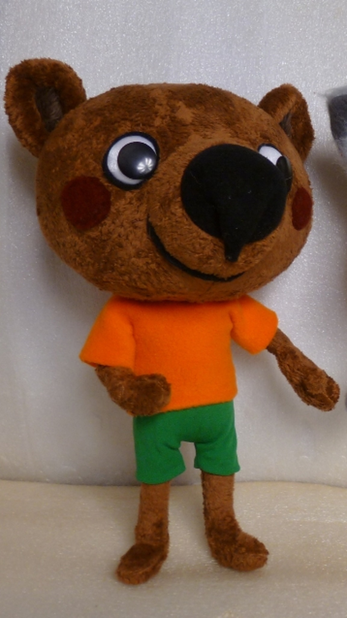 Cartoon bear plush in brown faux fur, orange T-shirt and green shorts, round eyes and big black nose, made to order
