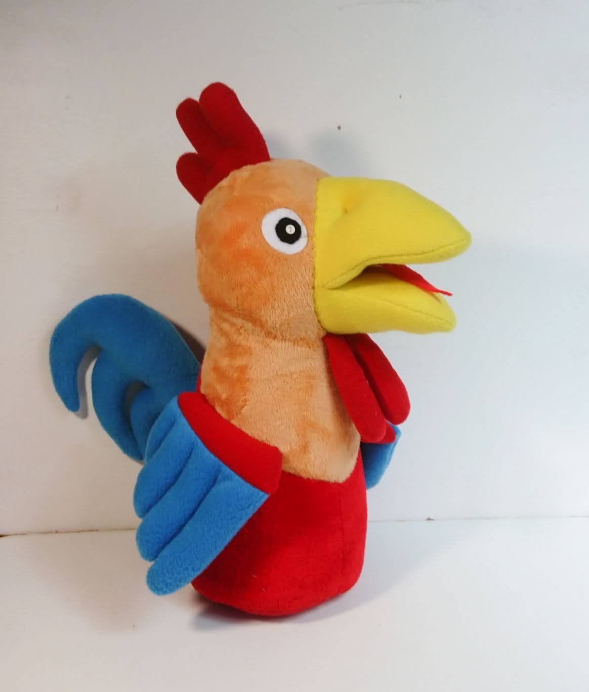 Cartoon rooster plush with a blue tail Cartoon rooster plush with a red comb, open yellow beak, sky-blue wings and curled tail, sewn by hand to order