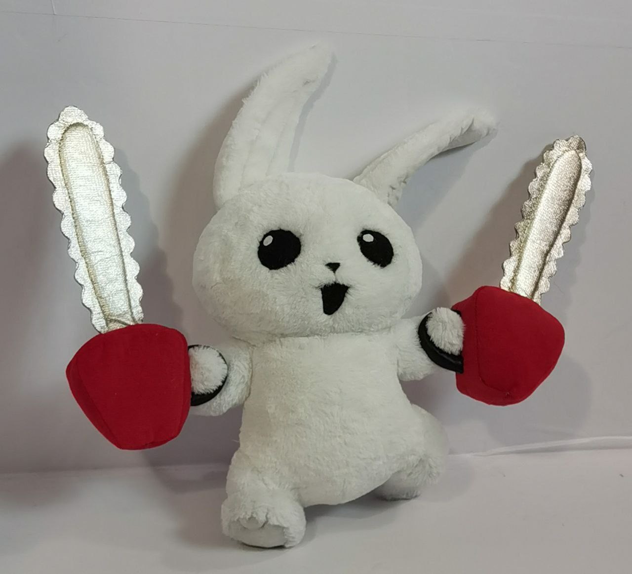 Chainsaw bunny plush with silver blades Chainsaw bunny plush raising two soft chainsaws with silver blades and red motor blocks, made to order