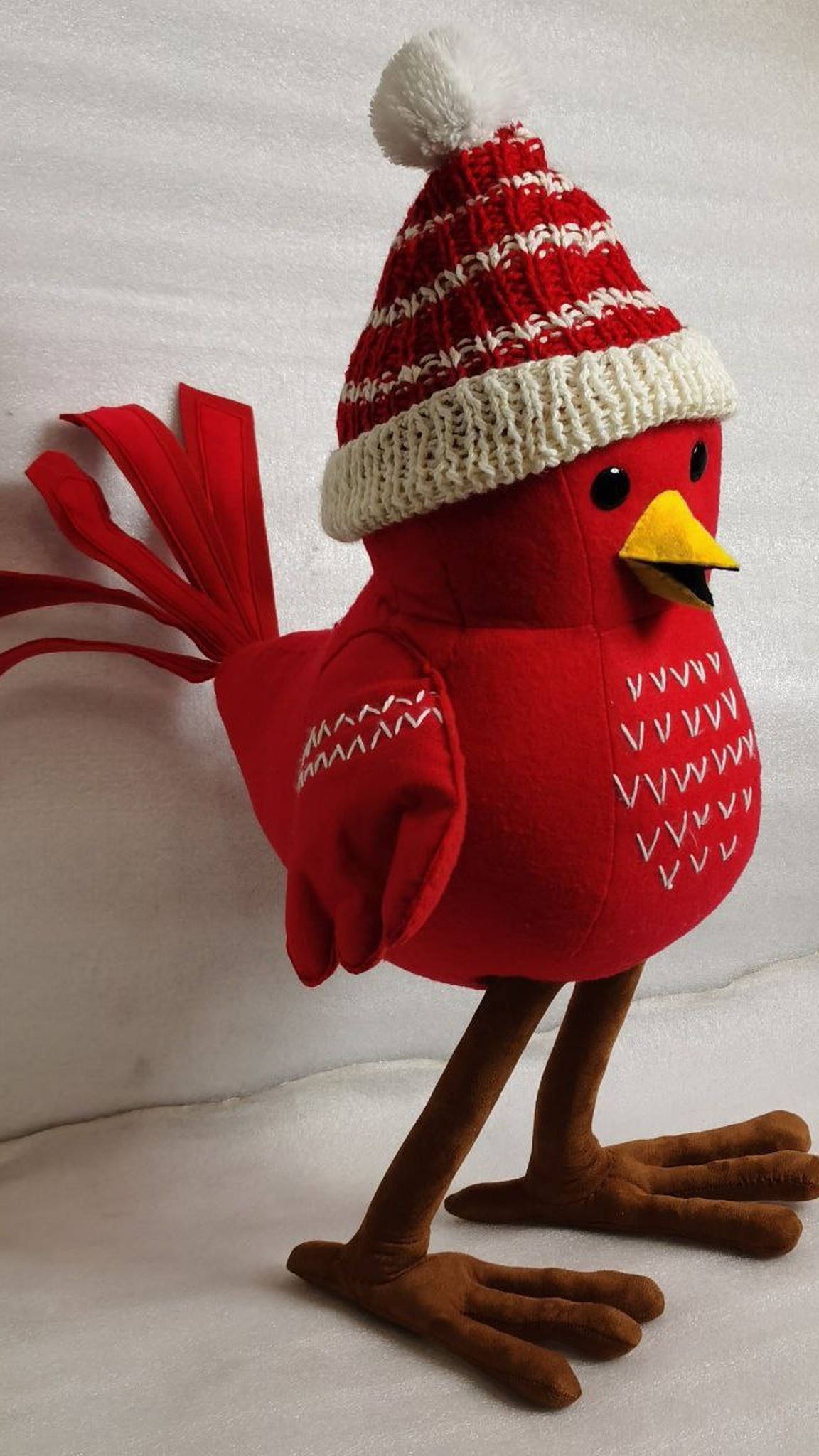Red Christmas bird plush in a cream bobble hat with zigzag stitched wings, made to order from a drawing