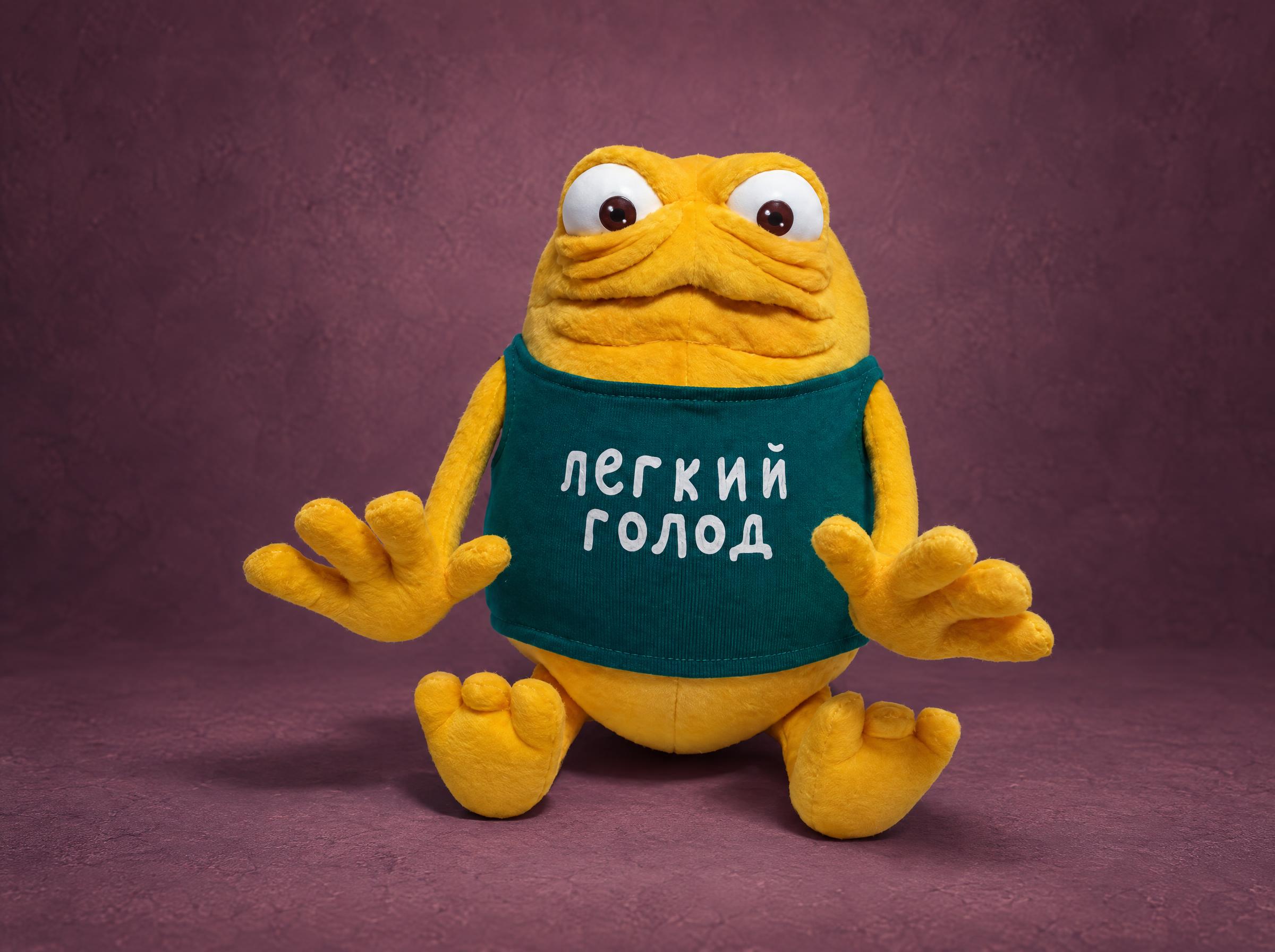 Yellow monster plush from a TV commercial in a green tank top, a custom mascot plush handmade to order