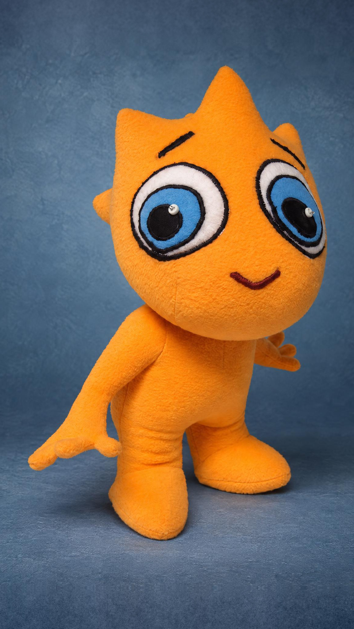 Custom cartoon mascot plush in orange fleece, big blue stitched eyes and cone spikes, sewn by hand to order