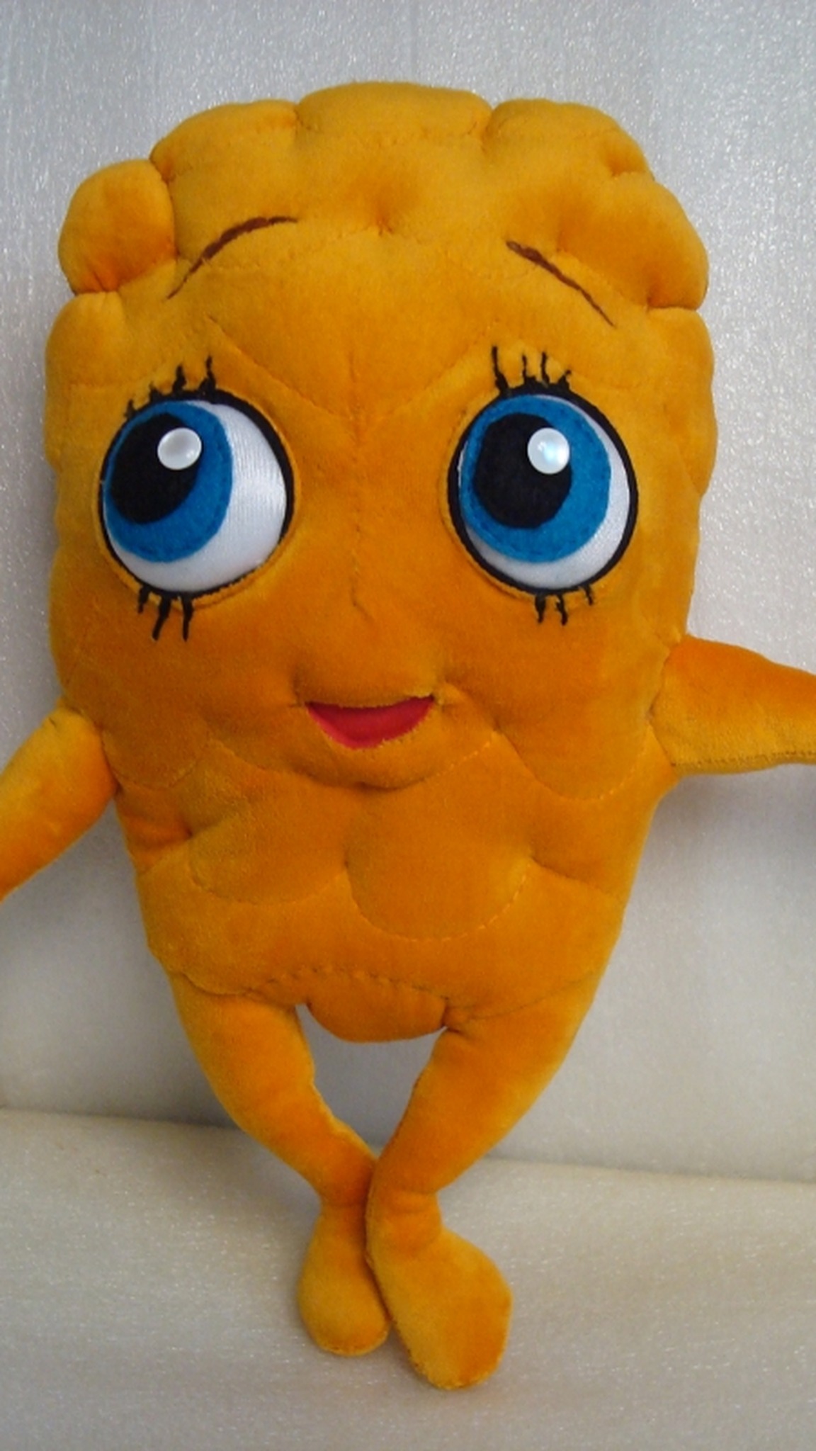 Handmade cookie mascot plush standing with crossed feet: orange quilted body, blue eyes, red mouth, made to order