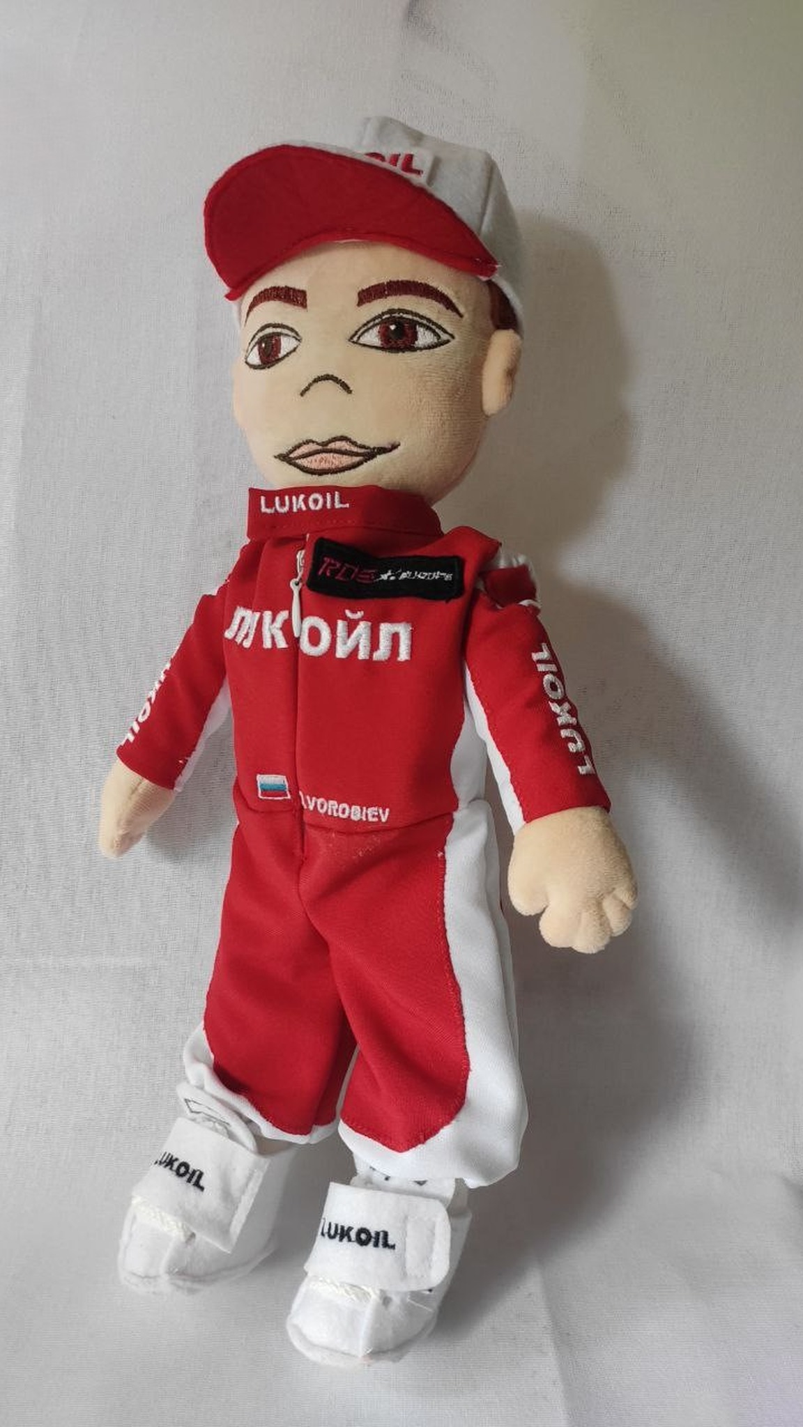 Corporate gift plush doll of a racer in a red suit and red and white cap, handmade to order