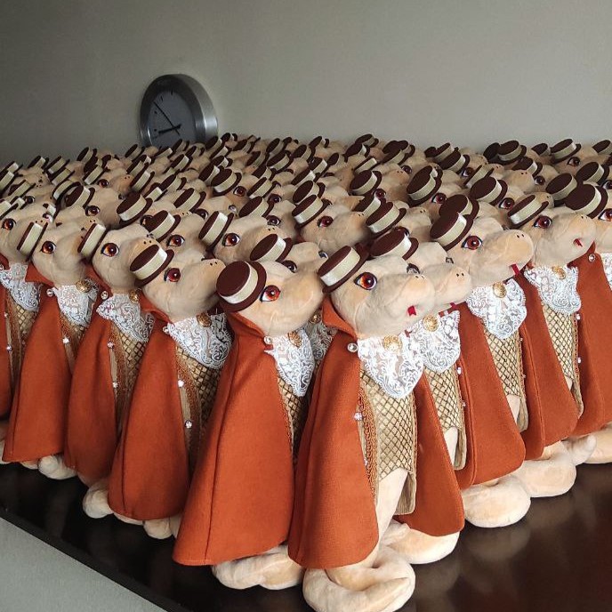 Corporate plush toys batch: snake gentlemen Rows of snake plush gentlemen in capes and top hats, a custom corporate New Year gift batch made by hand