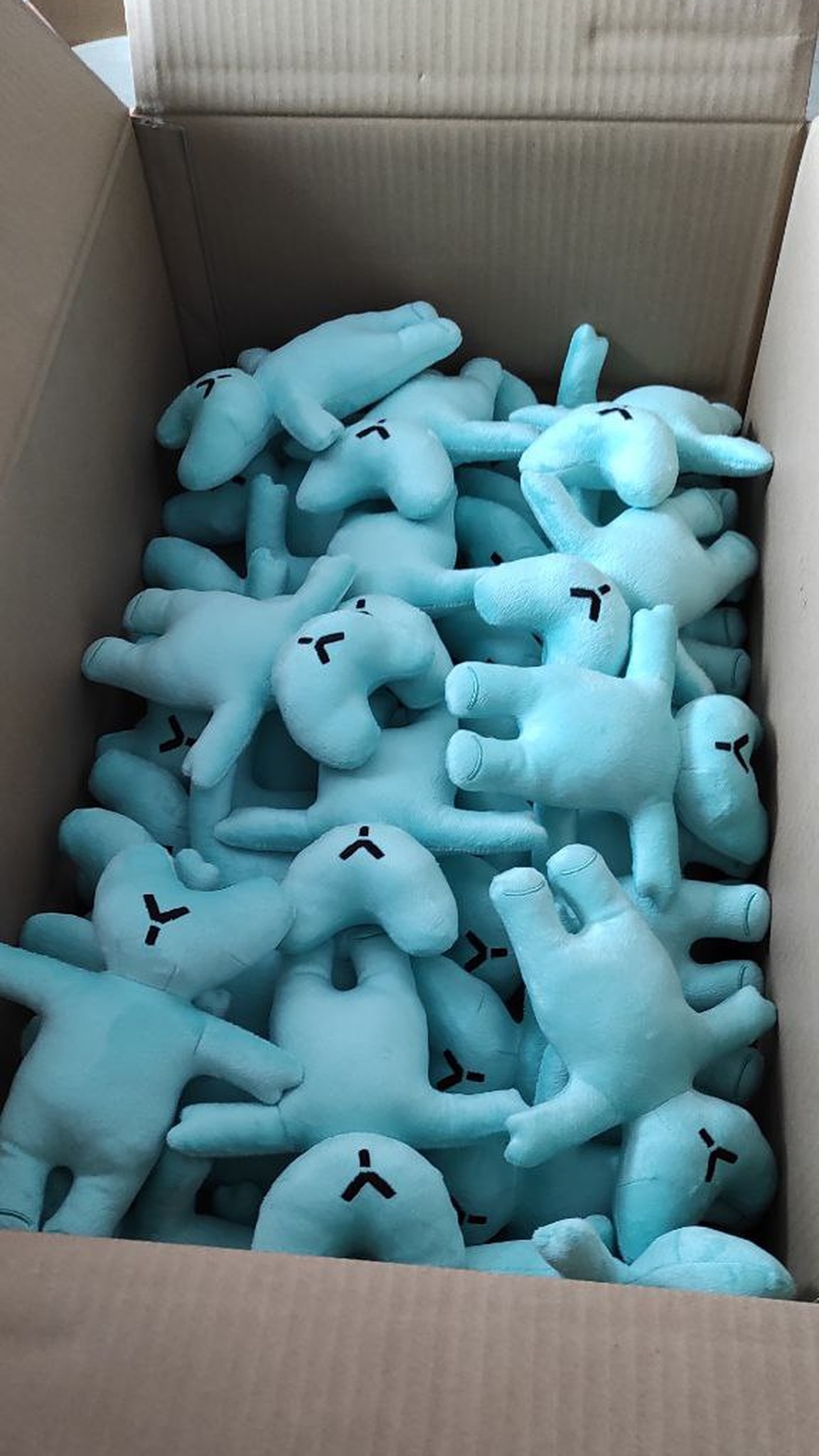 Box full of corporate teddy bears with embroidered logos, mint plush, a bulk order sewn to order