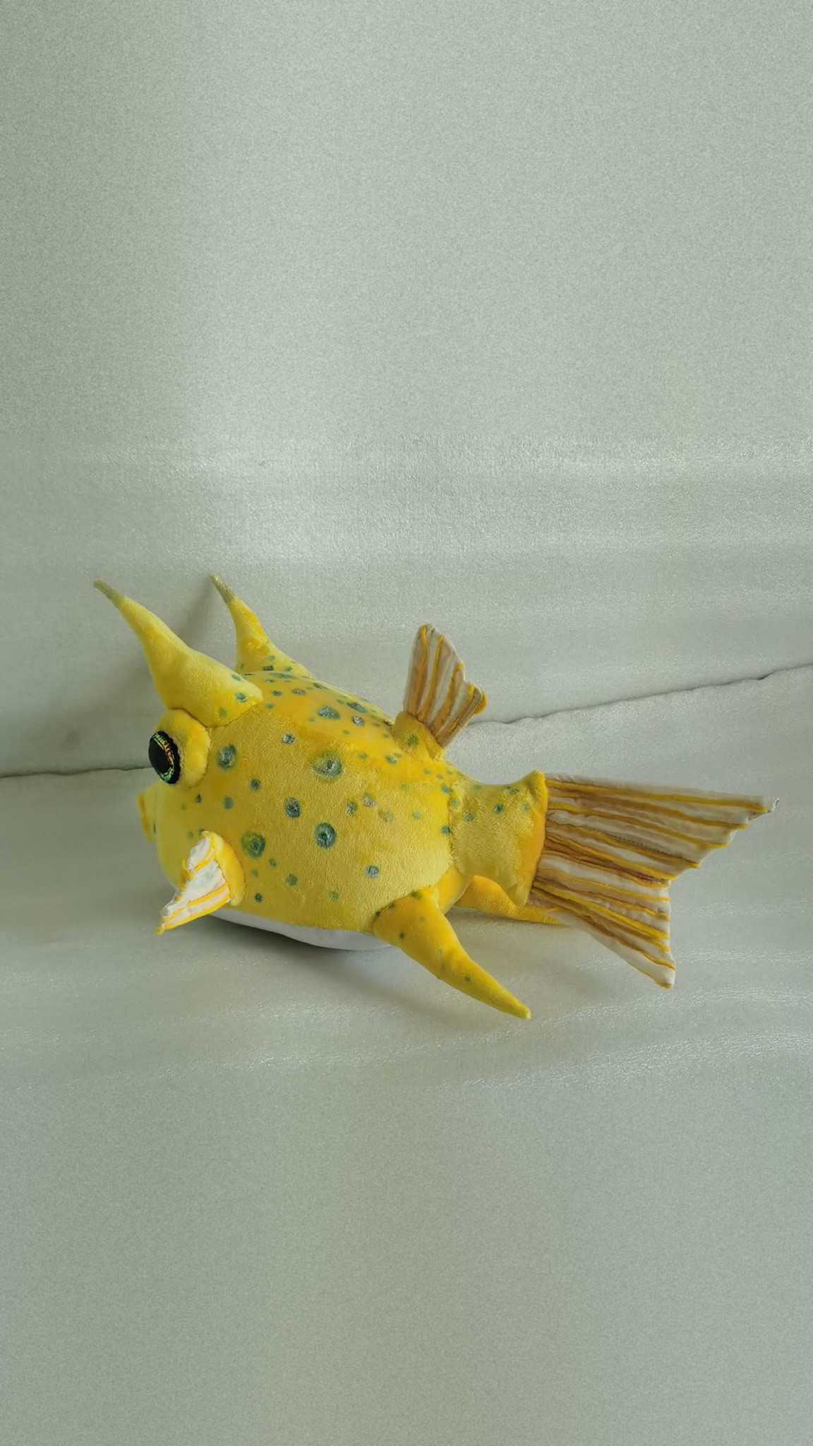 Cowfish plush with two yellow horns, a white belly and a striped fan tail, handmade to order