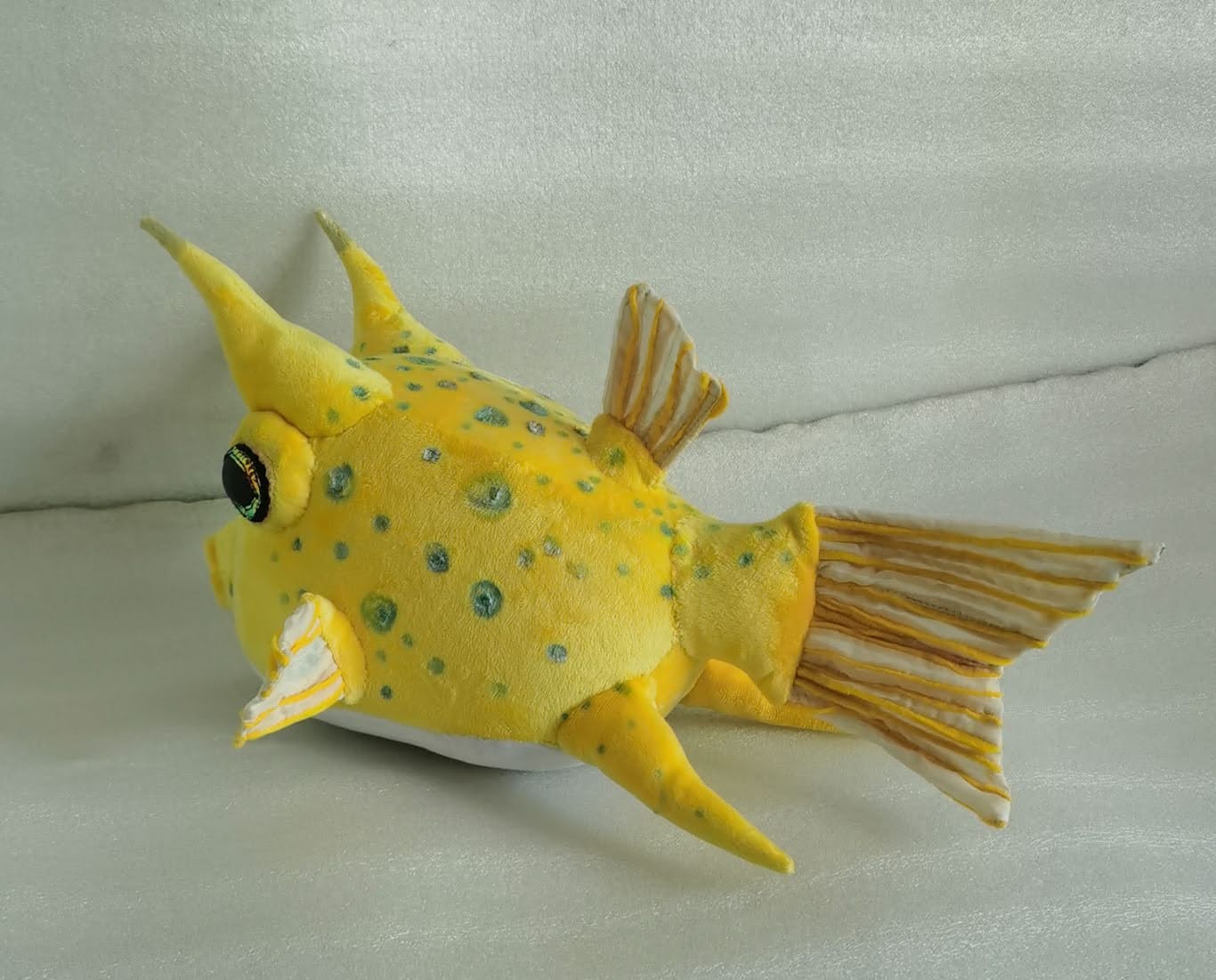 Cowfish plush with horns and striped tail Cowfish plush with two yellow horns, a white belly and a striped fan tail, handmade to order