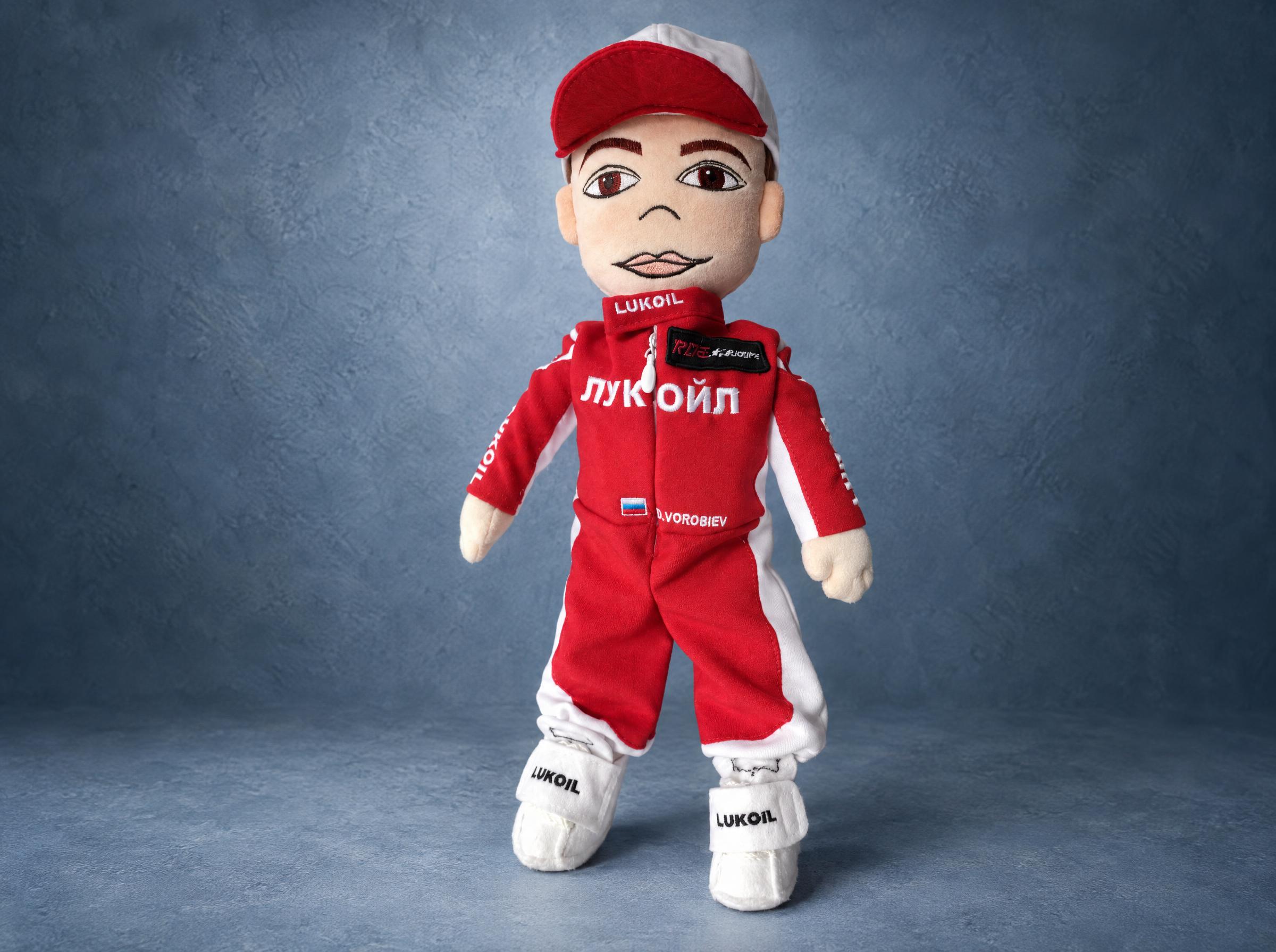 Custom branded plush doll in a red and white racing suit with an embroidered company logo, made to order