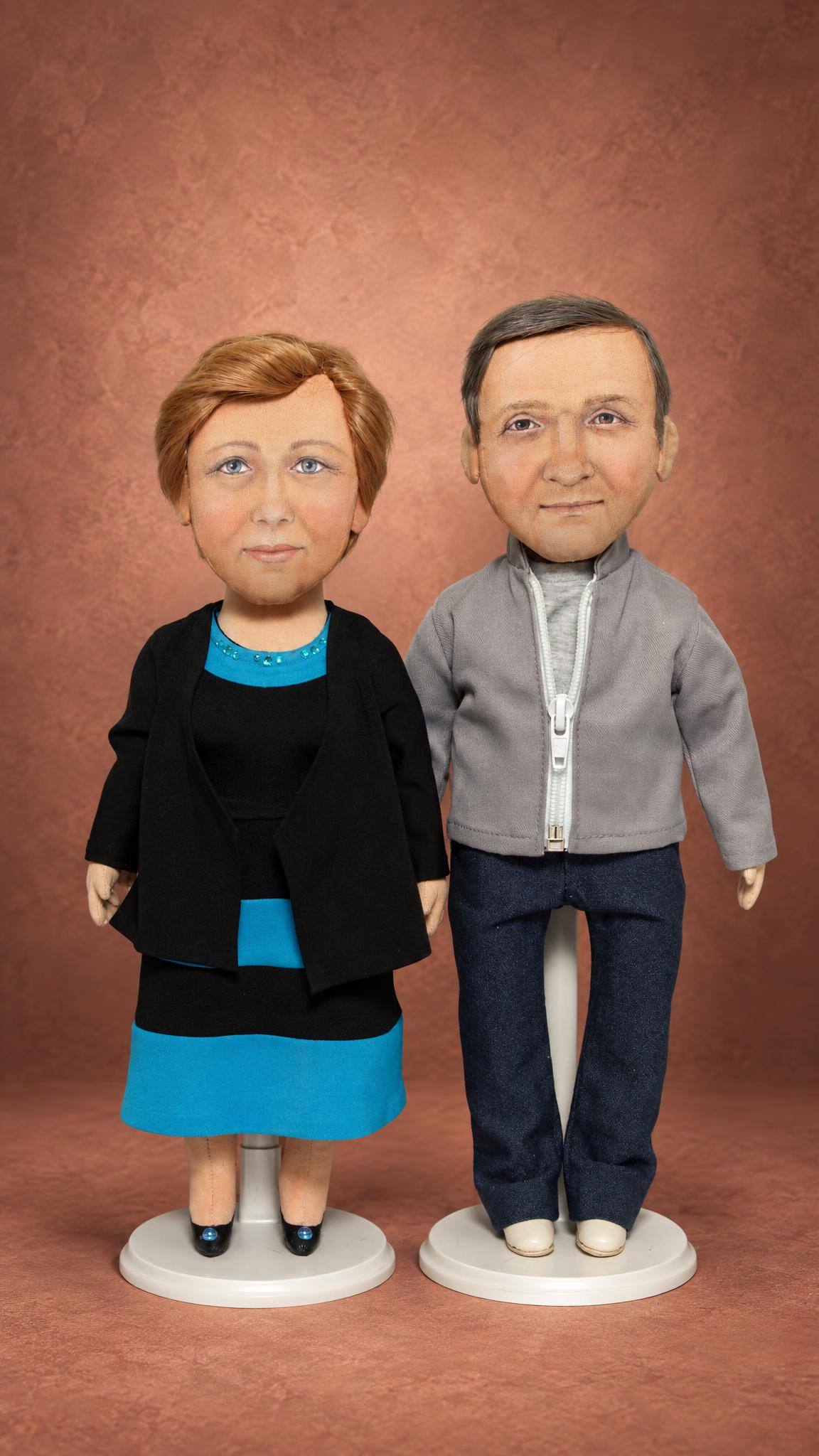 Custom couple dolls sewn from photos: auburn bob, rhinestone neckline, grey zip jacket, dark jeans, stands