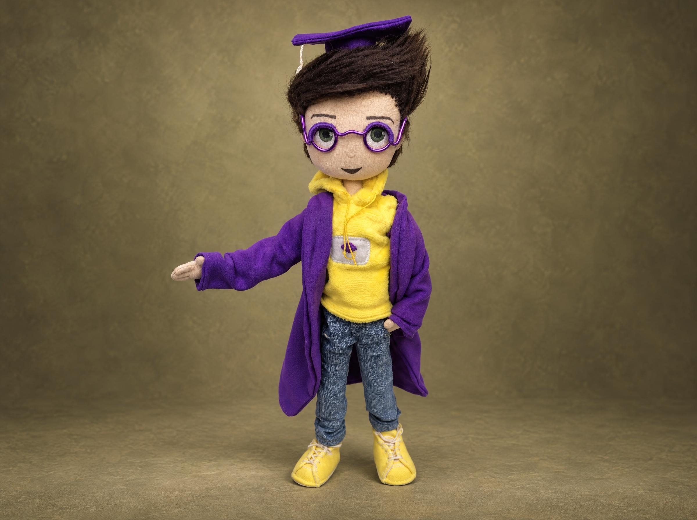 Custom graduation doll mascot in a violet cap and gown over a yellow hoodie, handmade to order from a drawing