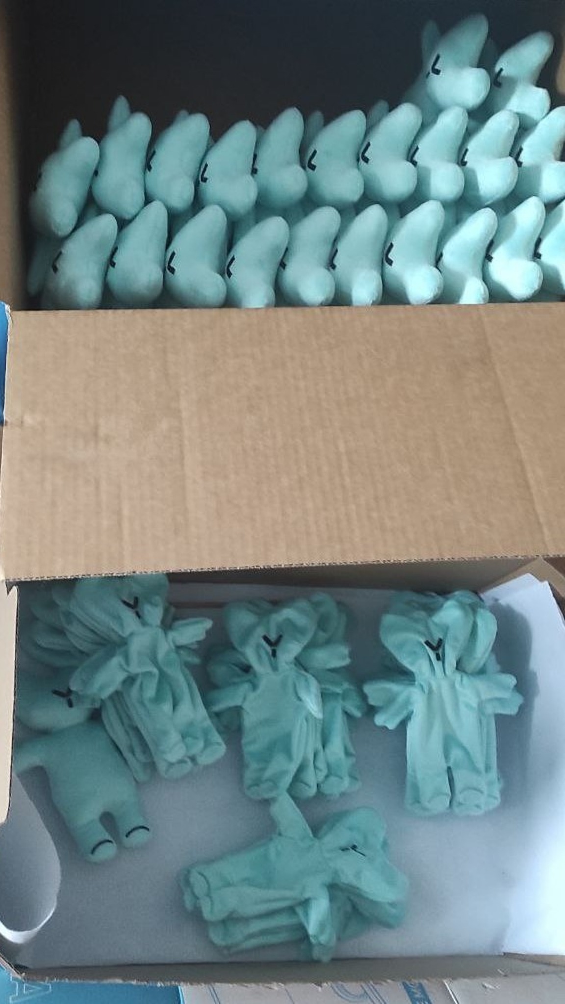 Custom logo teddy bears in production: stuffed mint bears and sewn bodies in boxes, made to order