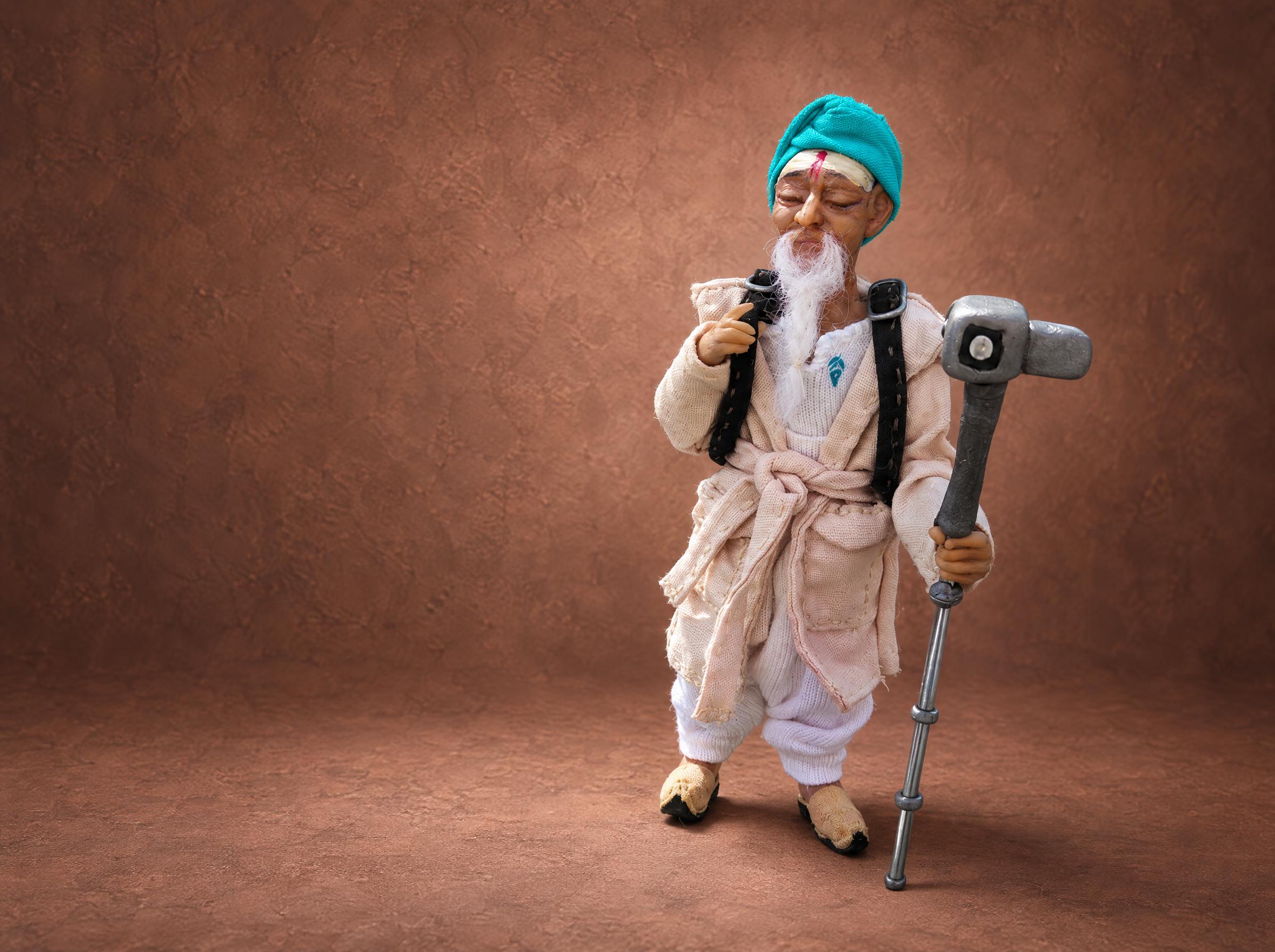 Custom mascot doll of an old traveler in a turquoise turban and cream coat, made to order for a travel brand