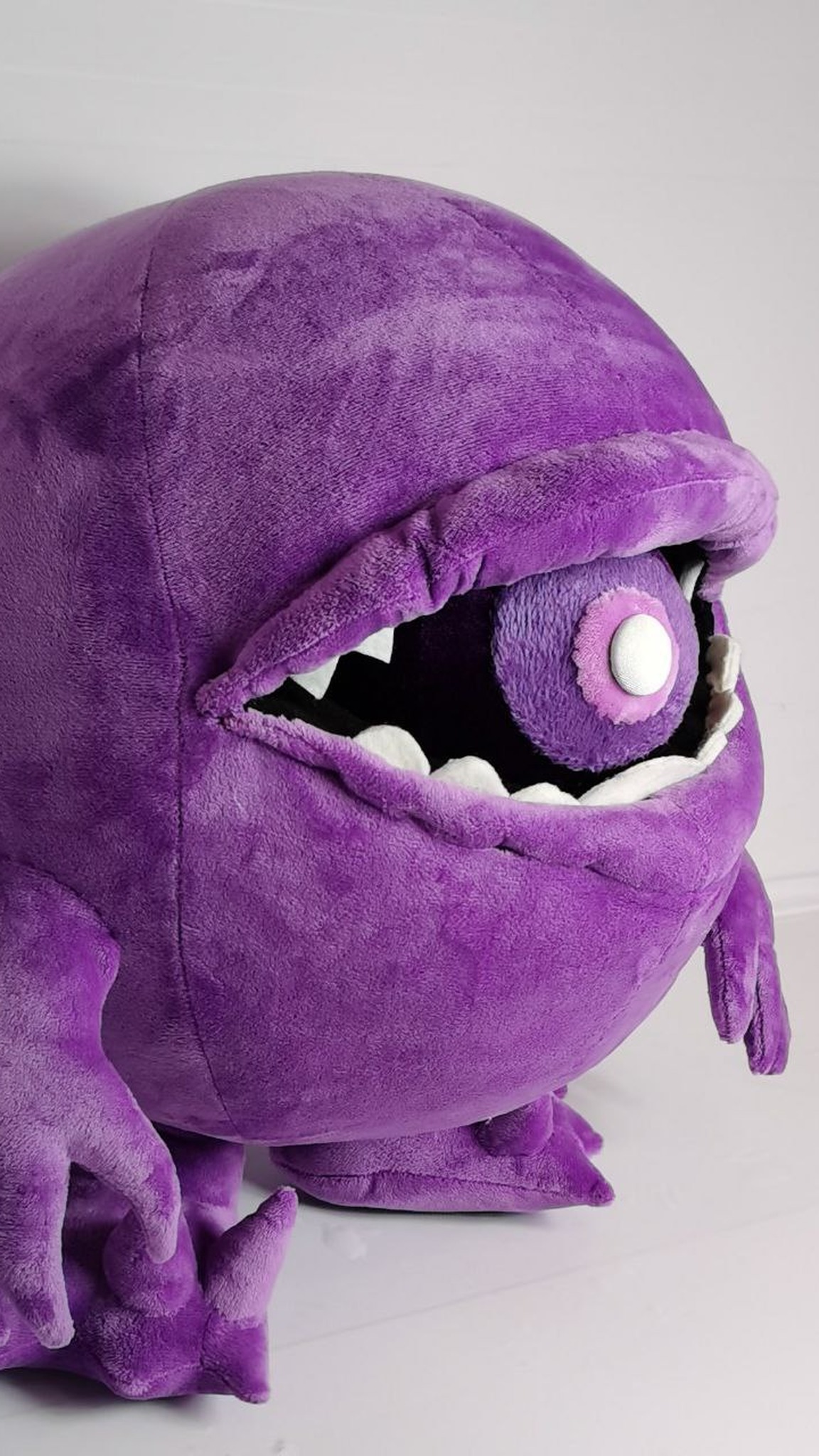 Custom monster plush in purple plush with a clawed arm and a ball in its toothy mouth, handmade to order
