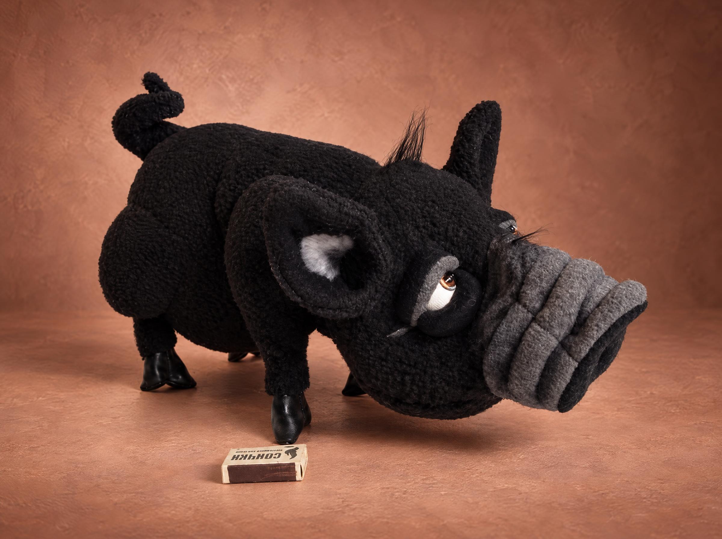 Custom pig plush of a black pet pig, sewn to order from a photo: folded grey snout, amber eyes, curly tail