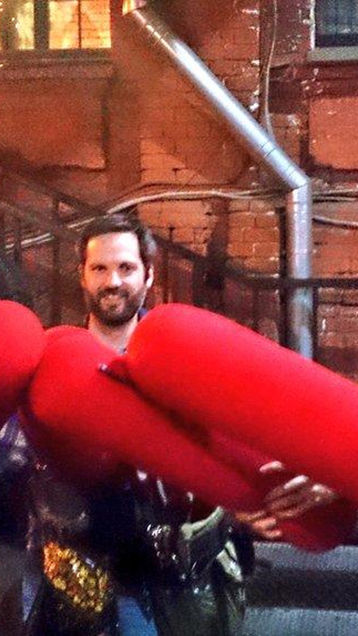 Custom red pillow fight sticks held by a team after a company party, soft batons handmade to order