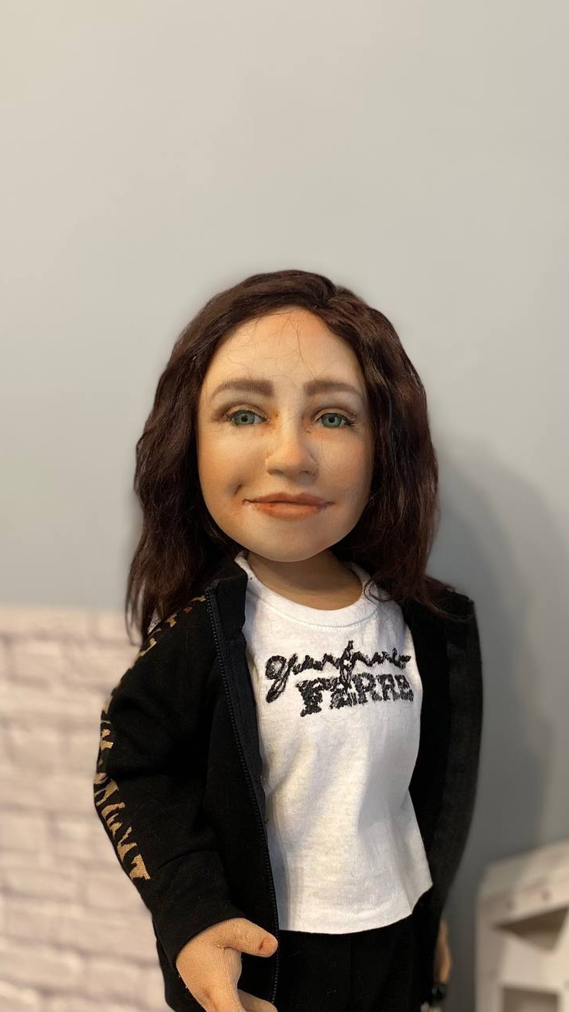 Custom portrait doll with a hand-painted face: green eyes, soft smile, dark wavy hair, white T-shirt