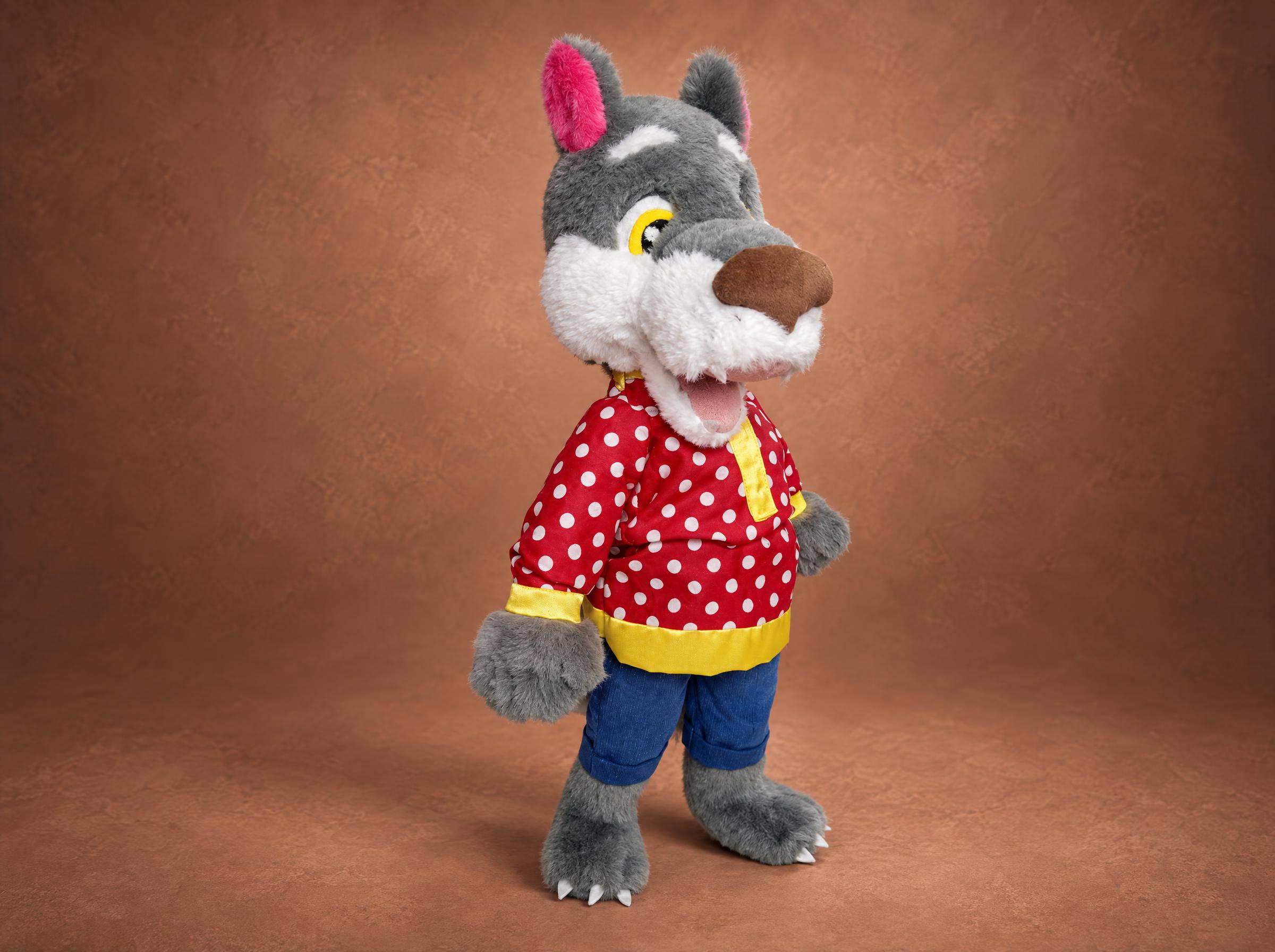Custom wolf plush made to order from a book: grey faux fur wolf cub in a red polka-dot shirt and blue trousers
