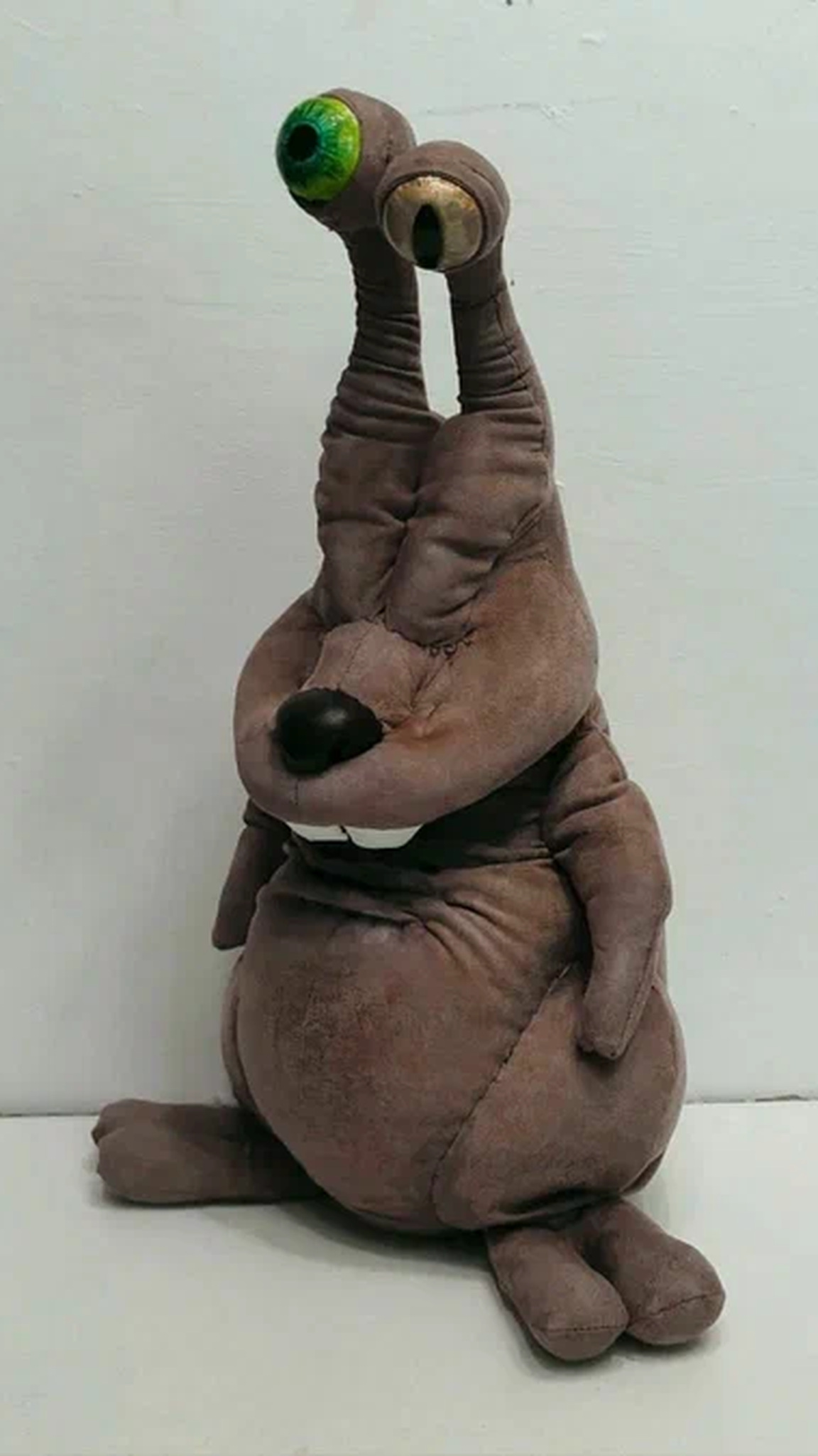 Handmade Zuzya creature plush sitting on long feet, round belly and green and yellow eyes, sewn to order