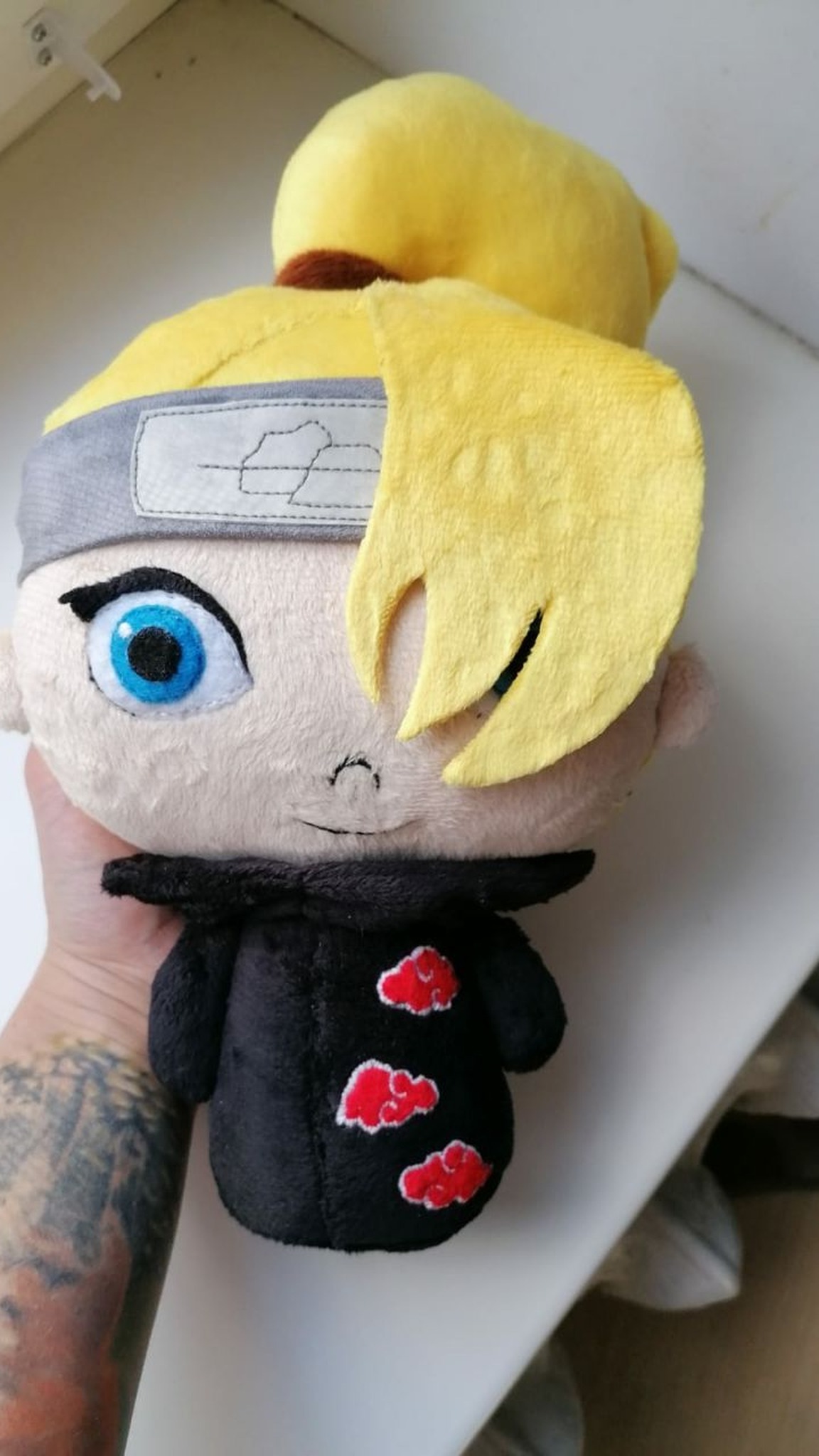 Chibi Deidara plush with a blue eye, yellow bang and red Akatsuki clouds on a black cloak, custom made