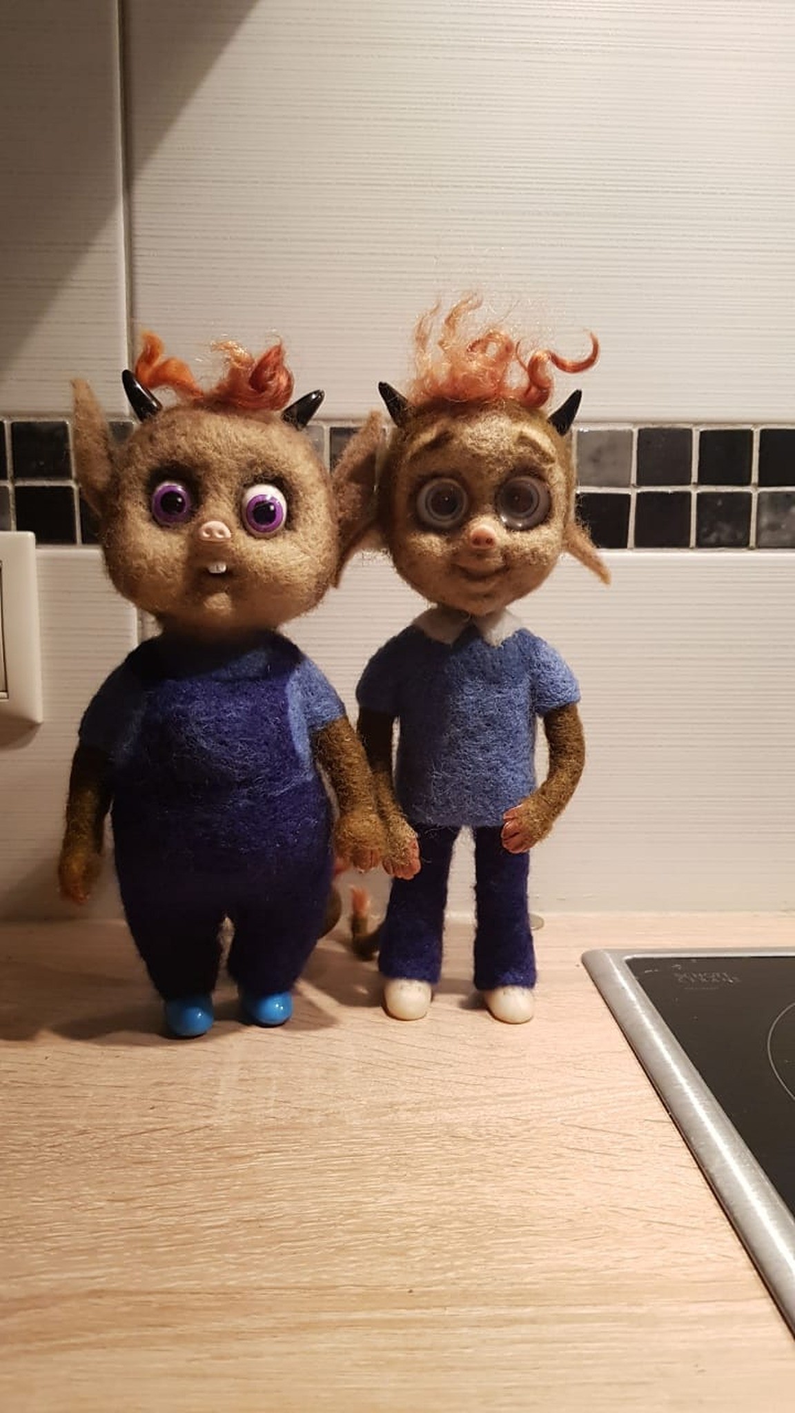 Two felted little devil dolls in blue clothes with horns and ginger curls, made to order from a book