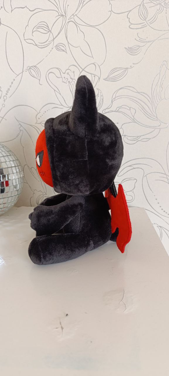 Devil plush mascot with horns and red wings Custom devil plush mascot in profile: black hood with soft horns, red face and red wing, sewn by hand to order