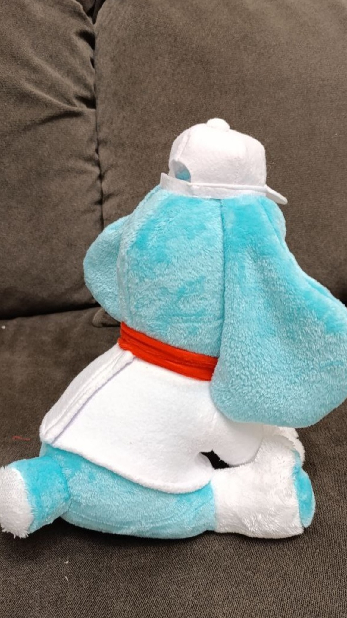 Handmade dog mascot plush with a sewn white T-shirt, cap and red ribbon over long turquoise ears, made to order