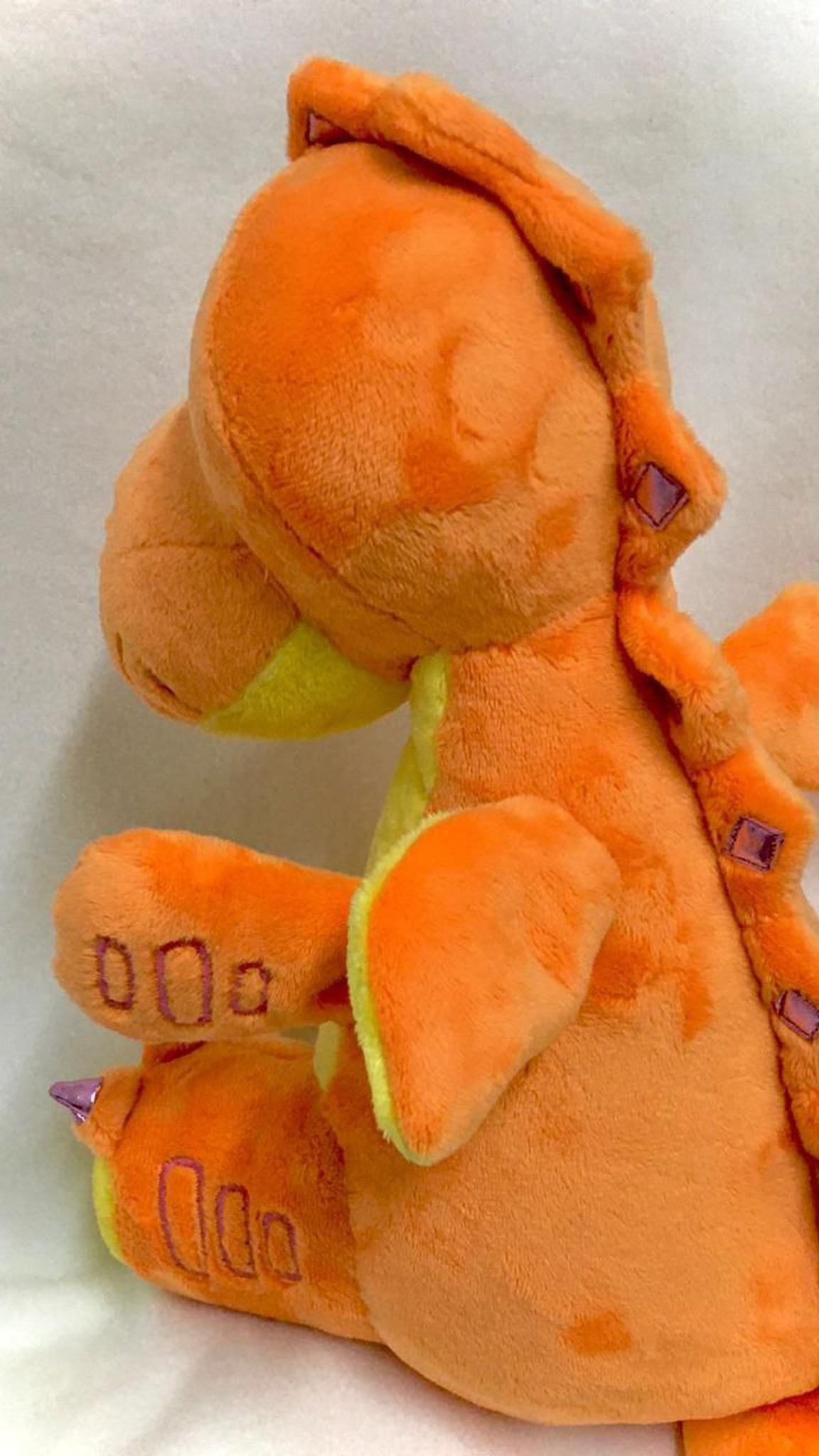 Dragon plush replica with purple spikes down an orange back, lime wing and stitched toe lines, handmade copy