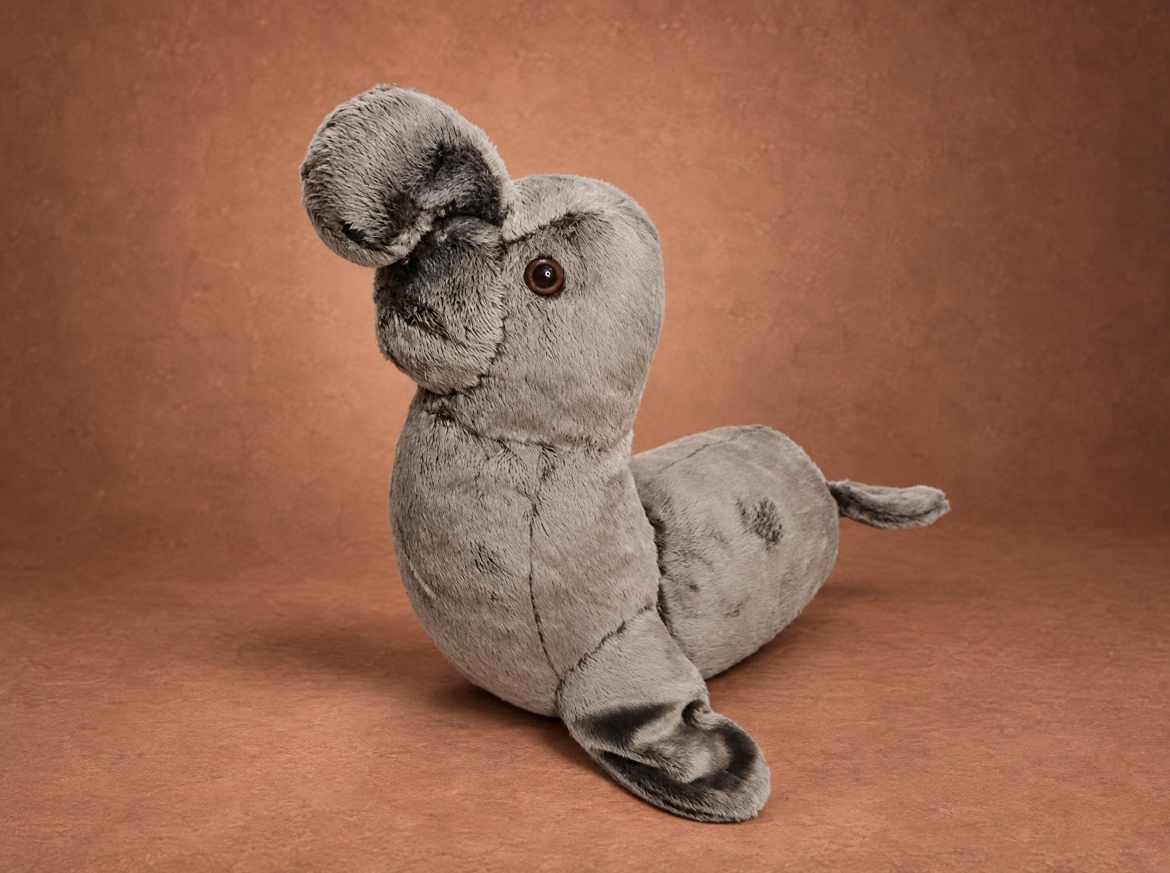 Elephant seal plush in grey faux fur with a floppy trunk nose and dark flipper tips, sewn to order