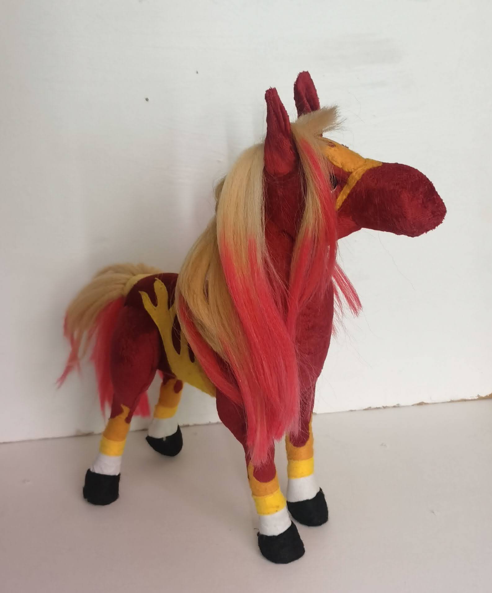 Red horse plush with a blonde and red mane Red horse plush with a long blonde mane turning red at the tips, white socks and black hooves, sewn to order