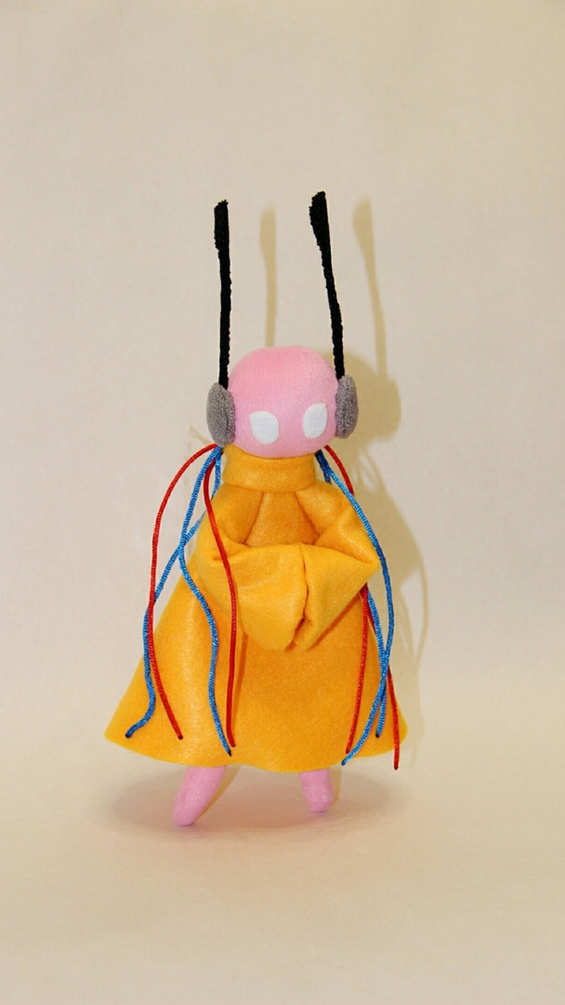 Five Pebbles plush from Rain World with folded yellow sleeves and white eyes, a custom iterator made to order