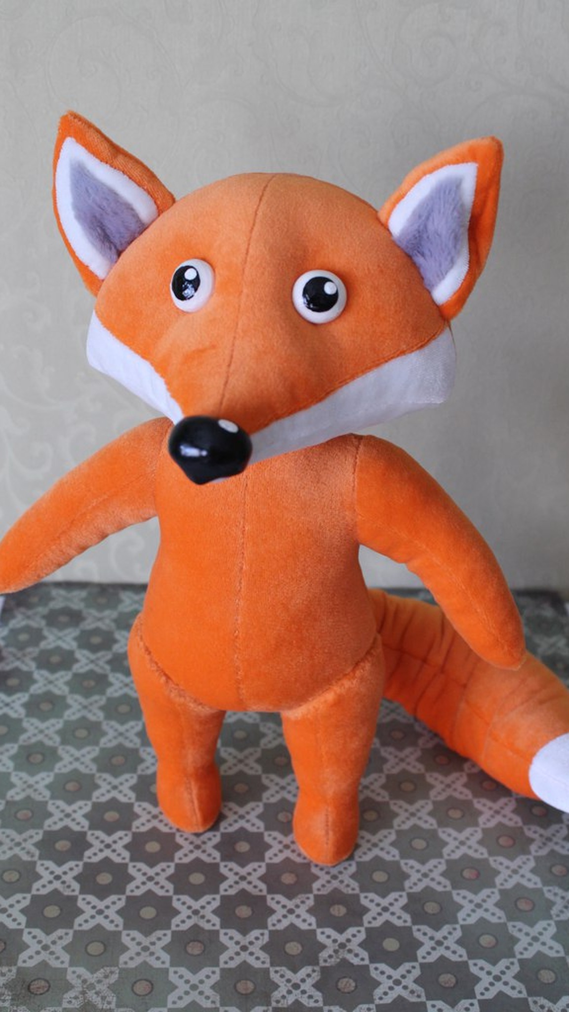 Orange fleece fox plush with lilac-lined ears and a white chest, the body of a custom company mascot