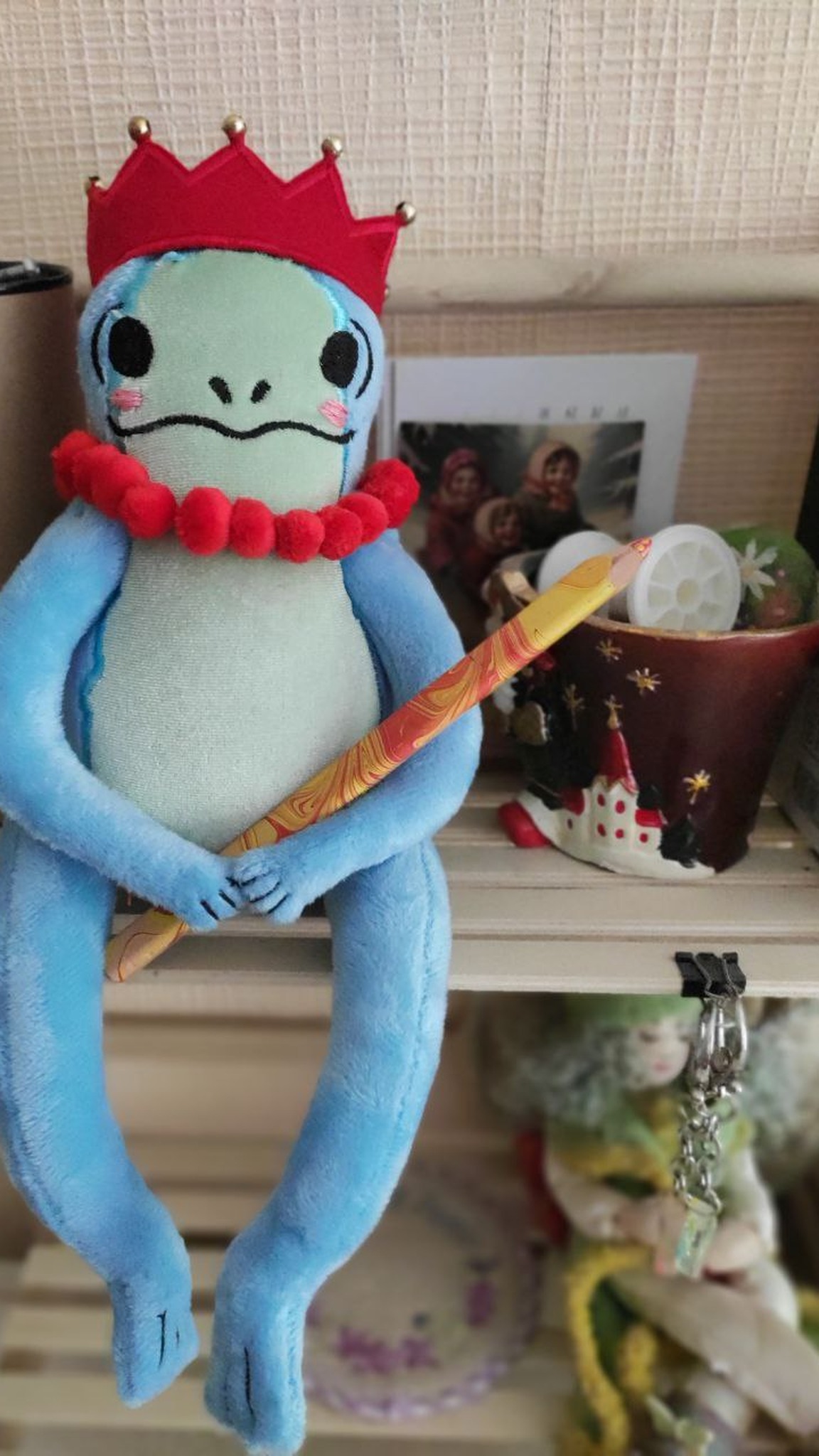 Frog princess plush holding a pencil like a sceptre, red crown with gold beads, custom sticker toy