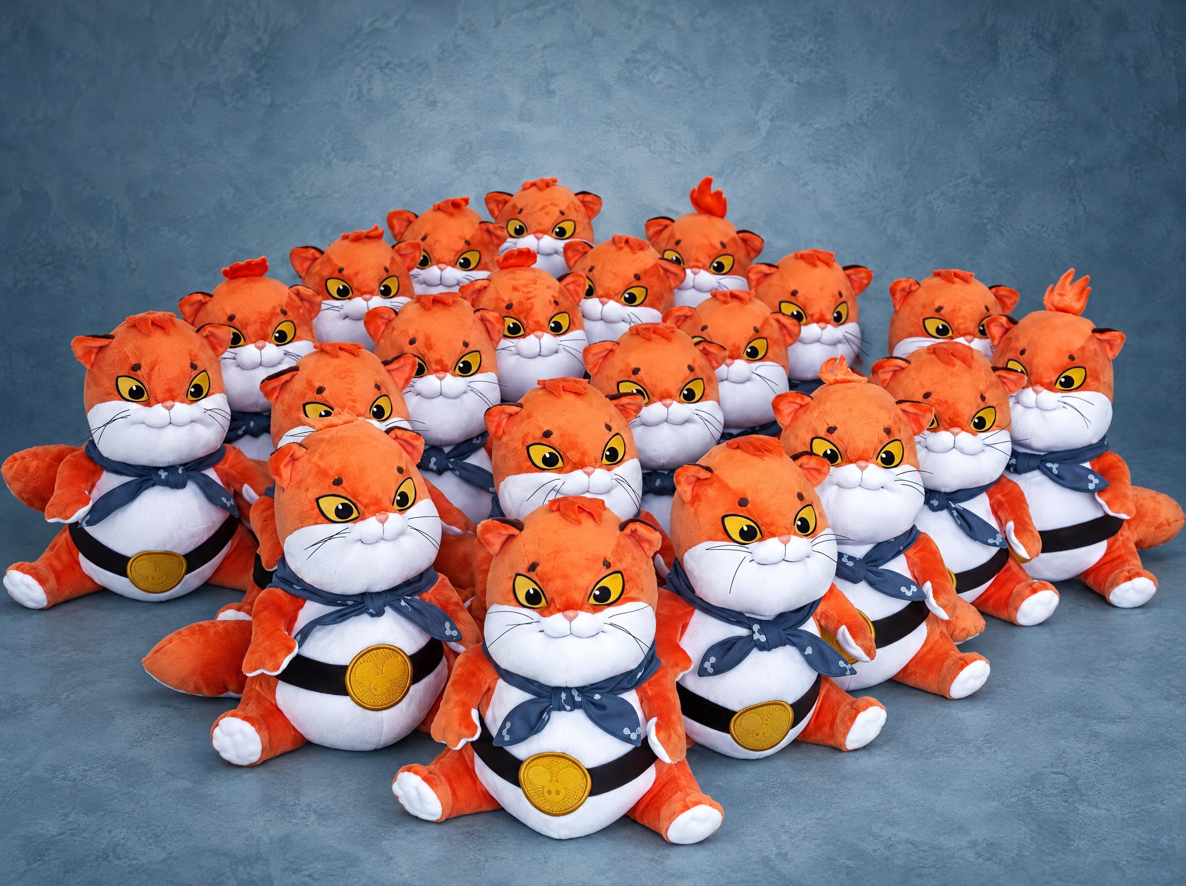 Batch of ginger cat game merch plush with bandanas and gold belt badges, handmade to order for a game studio