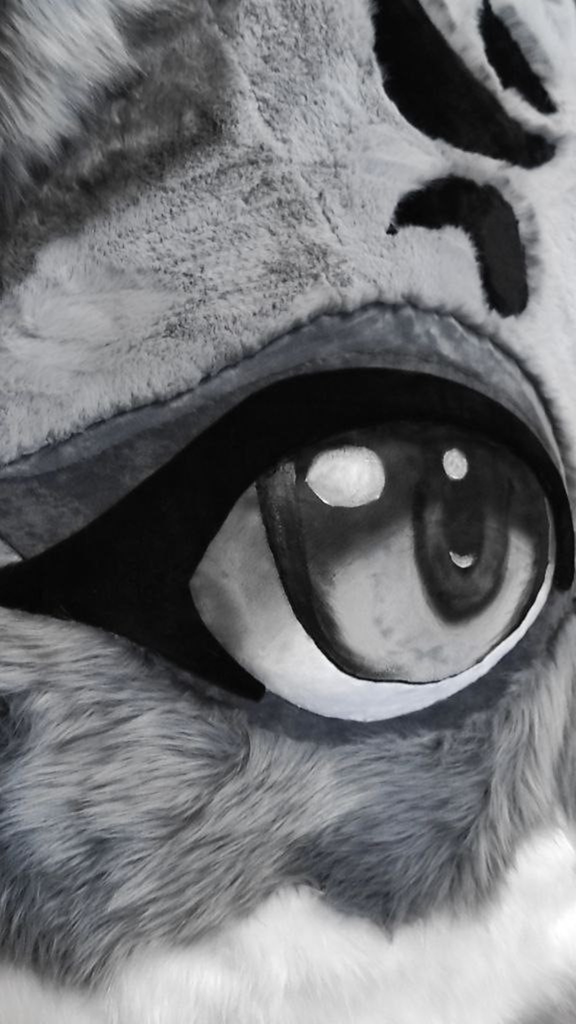 Painted anime eye of the giant fox head plush, set in grey faux fur under the black forehead pattern, handmade