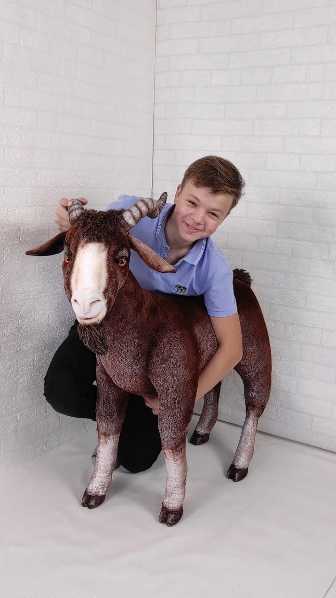 Giant goat stuffed animal next to a kneeling boy, horns level with his head, handmade to order